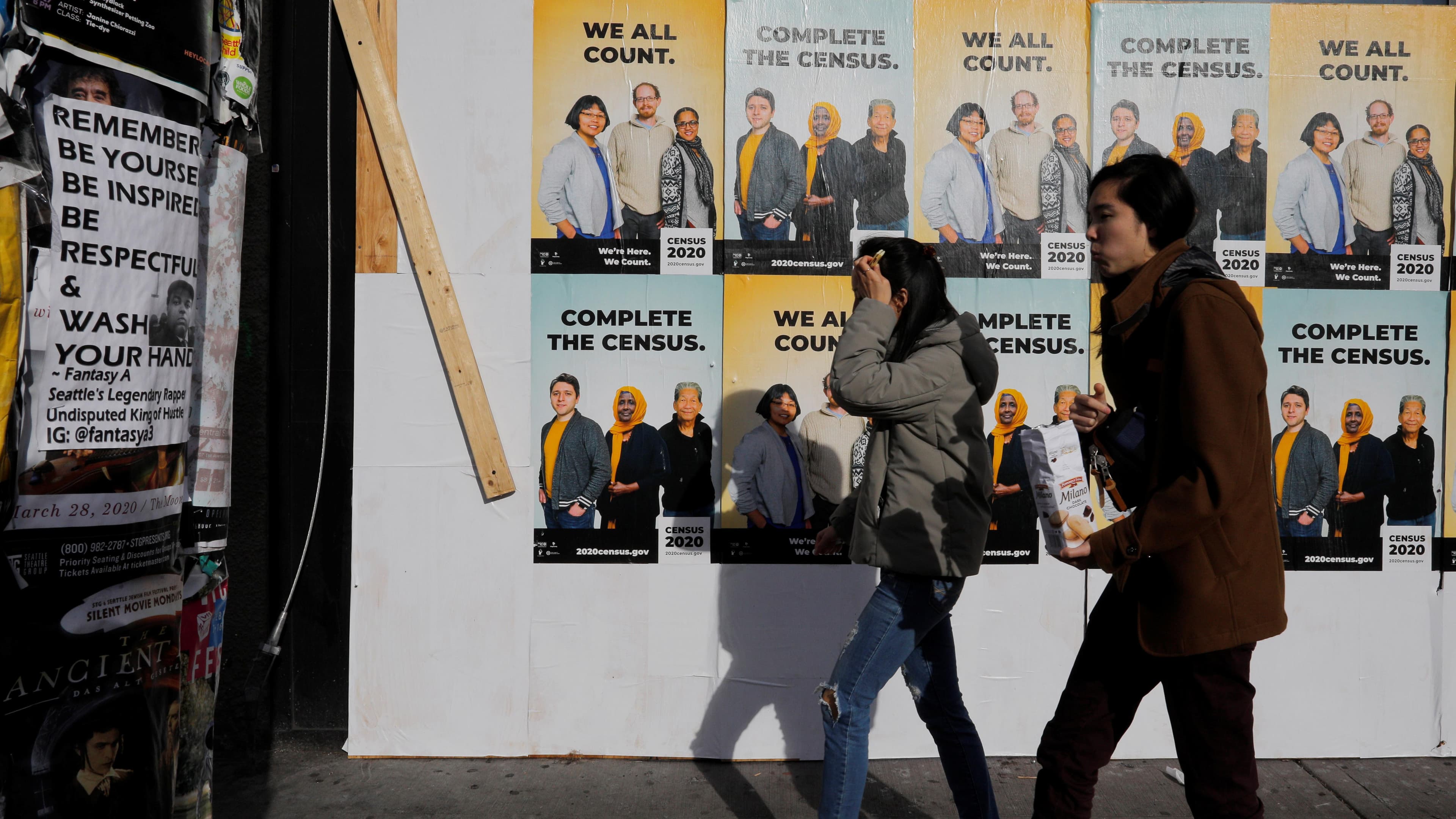 Signs advertising the 2020 US Census cover a closed and boarded up business amid the coronavirus outbreak in Seattle, Washington, March 23, 2020.