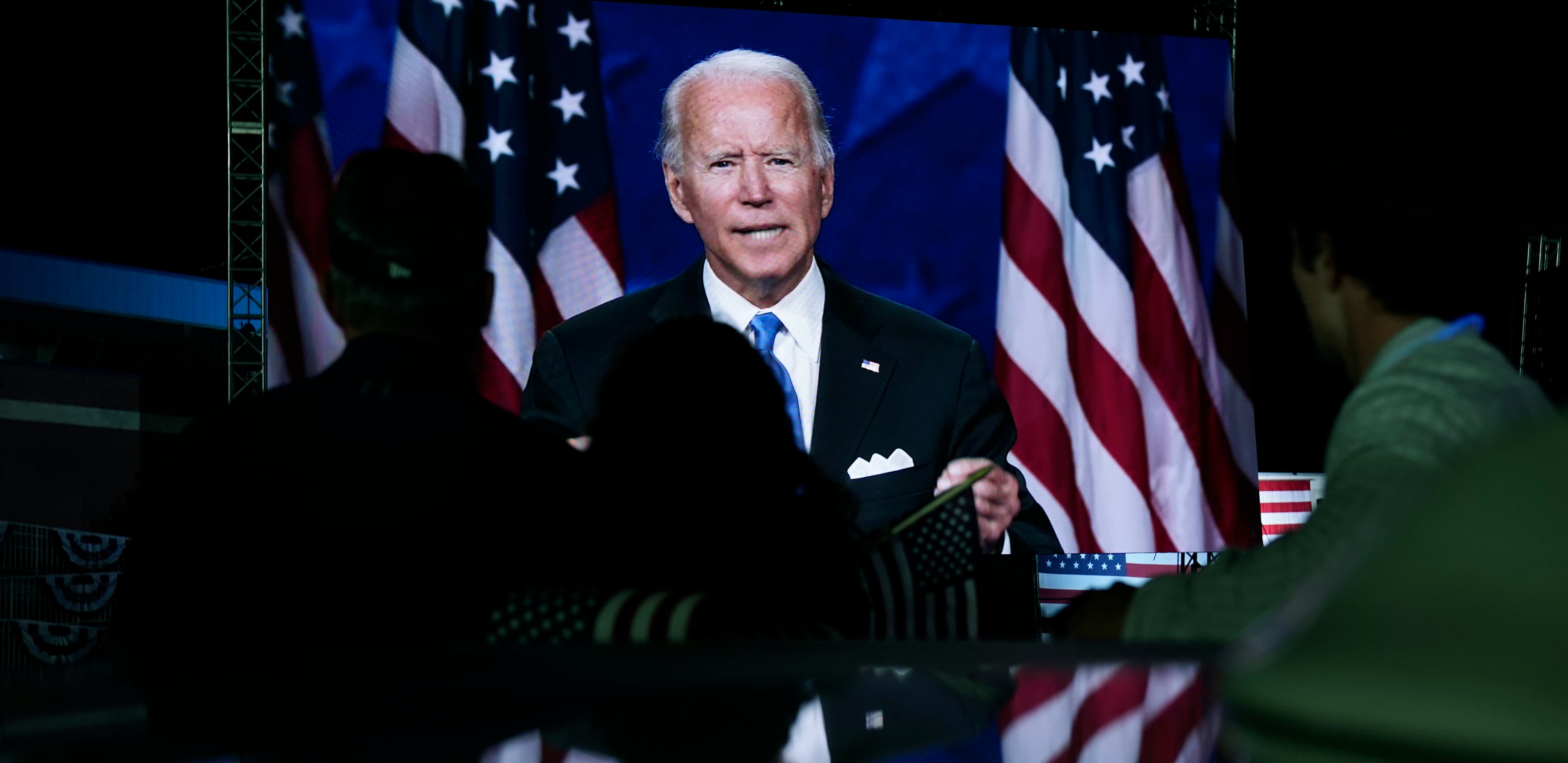 In this Aug. 20, 2020, file photo supporters watch the program outside the venue where Democratic presidential candidate former Vice President Joe Biden is speaking, during the Democratic National Convention at the Chase Center in Wilmington, Delaware.