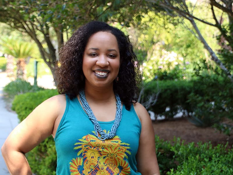 An image of a Black American woman wearing a blue, sleeveless dress