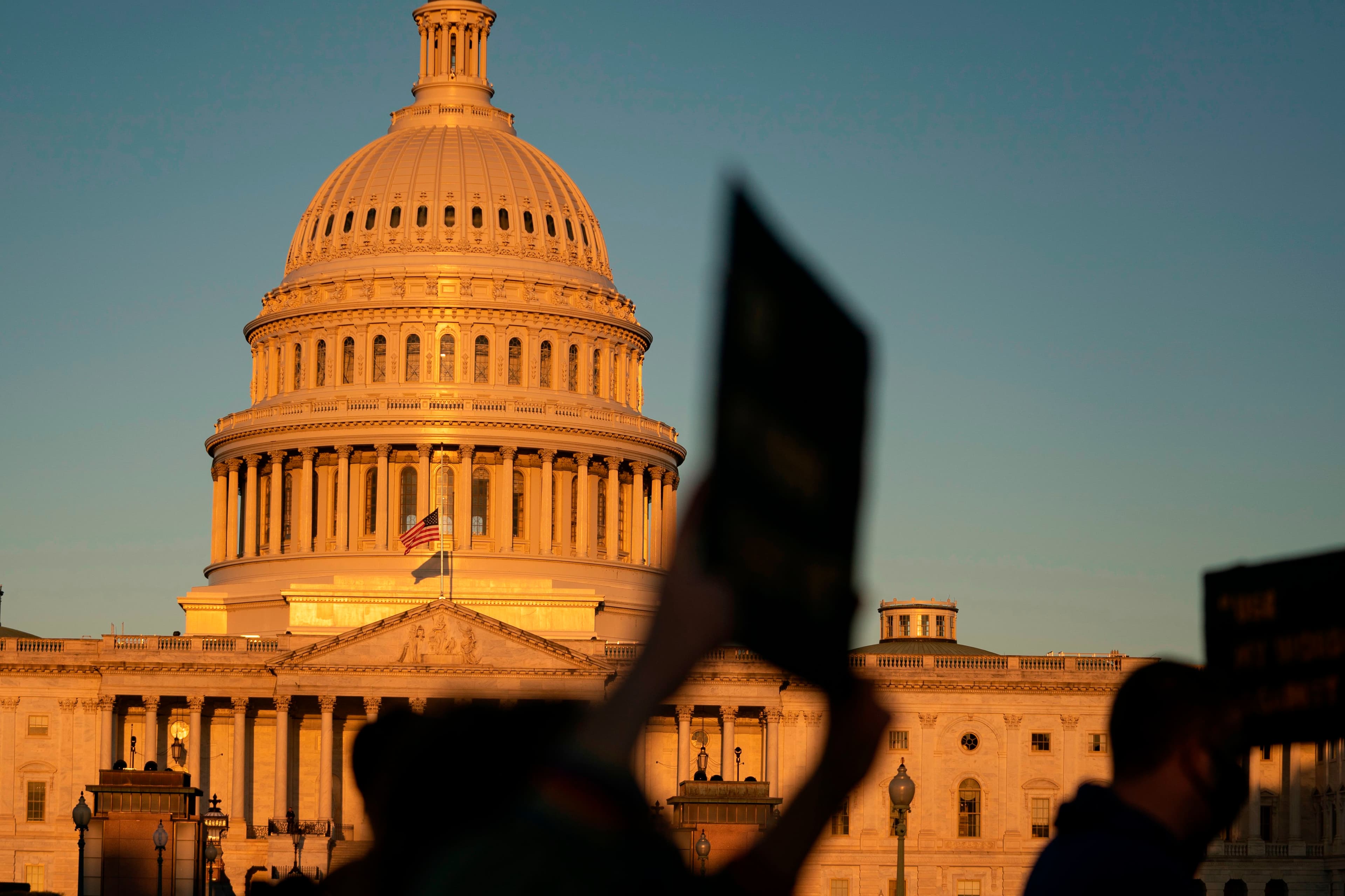 A silhouette of protest signs outside the US Capitol