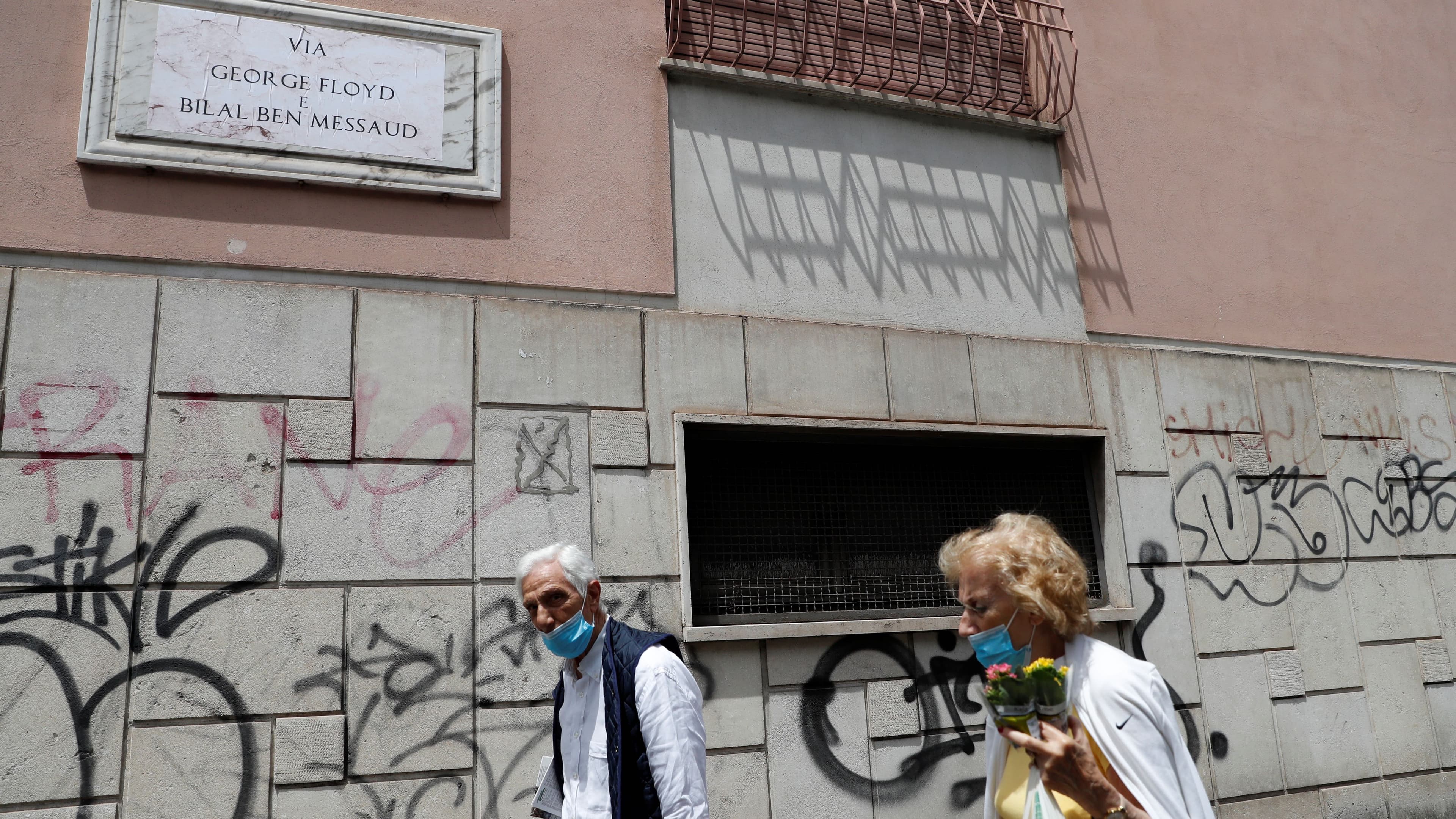 People walk near the former street sign for ''Via dell'Amba Aradam''