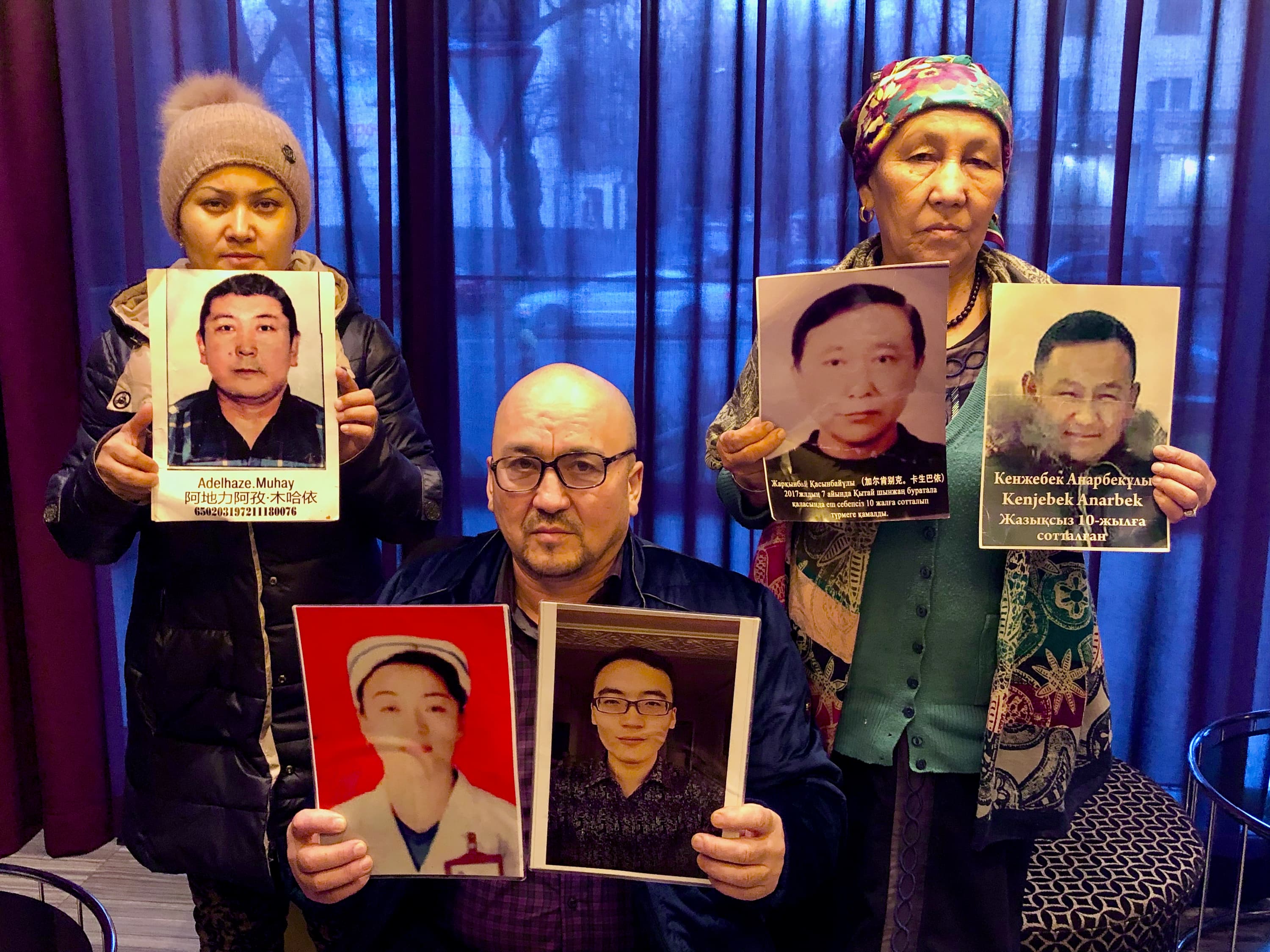 Kazakhs in Almaty hold up photos of their relatives being held in detention in Xinjiang, China.