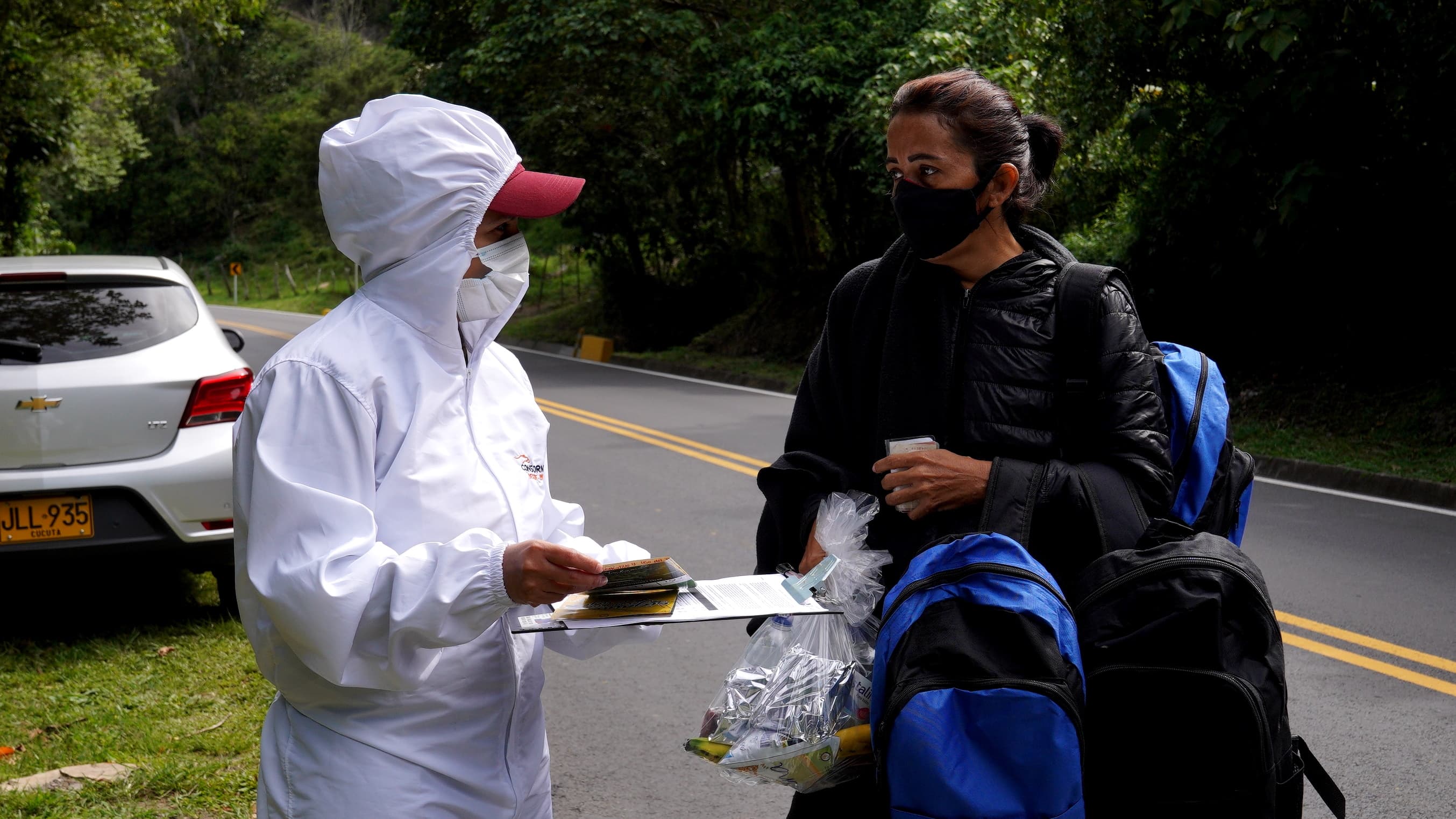 Veronica Gomez, who was traveling with her partner and her son, receives backpacks from a humanitarian worker on Oct 1. The backpacks included energy bars, toiletries and ski masks, for the cold weather.