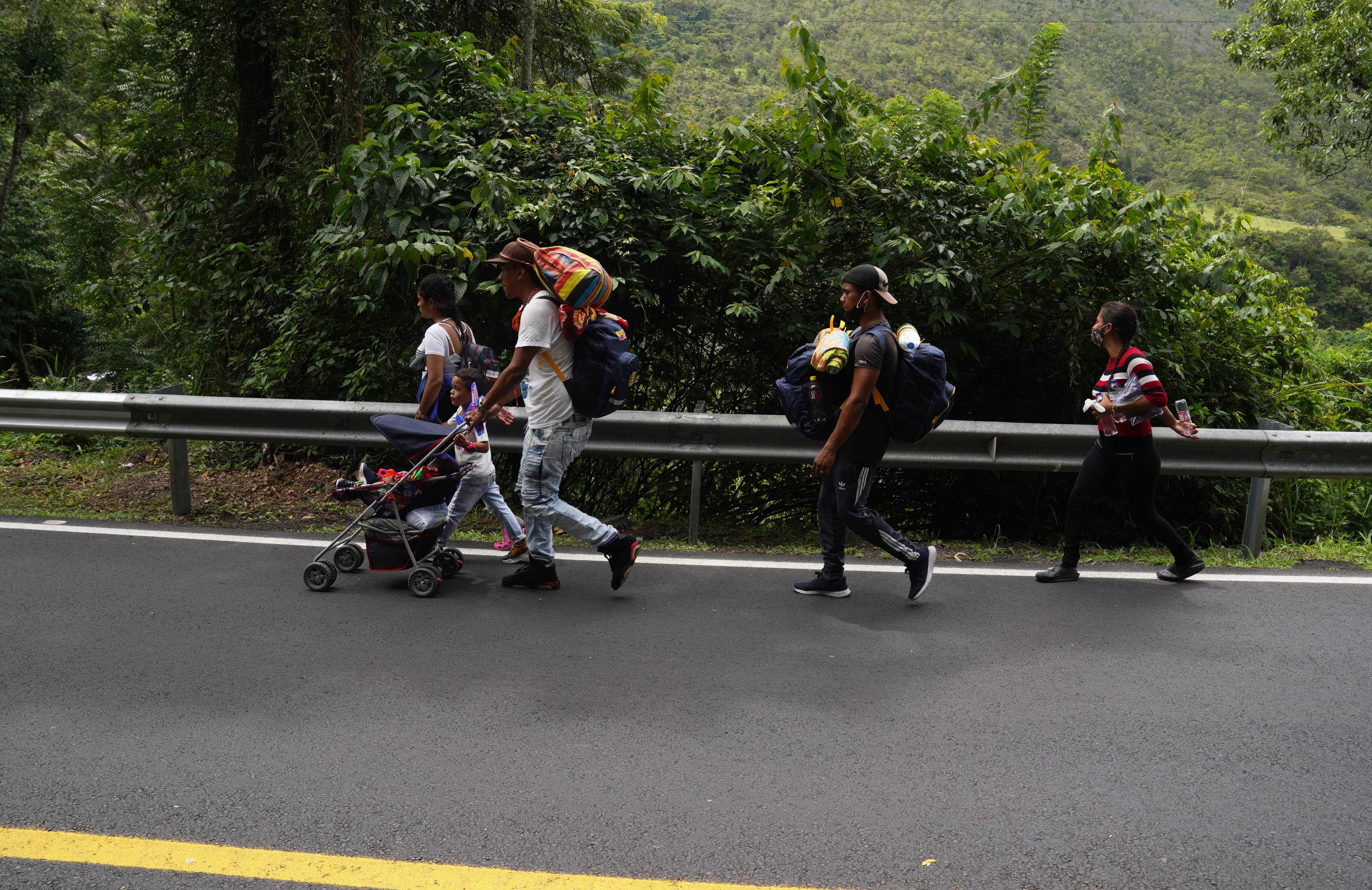 A family from Caracas, Venezuela walks along the road leading to Pamplona, Colombia, on Sept. 30. This family was heading to Ecuador where they had been promised work on a farm.