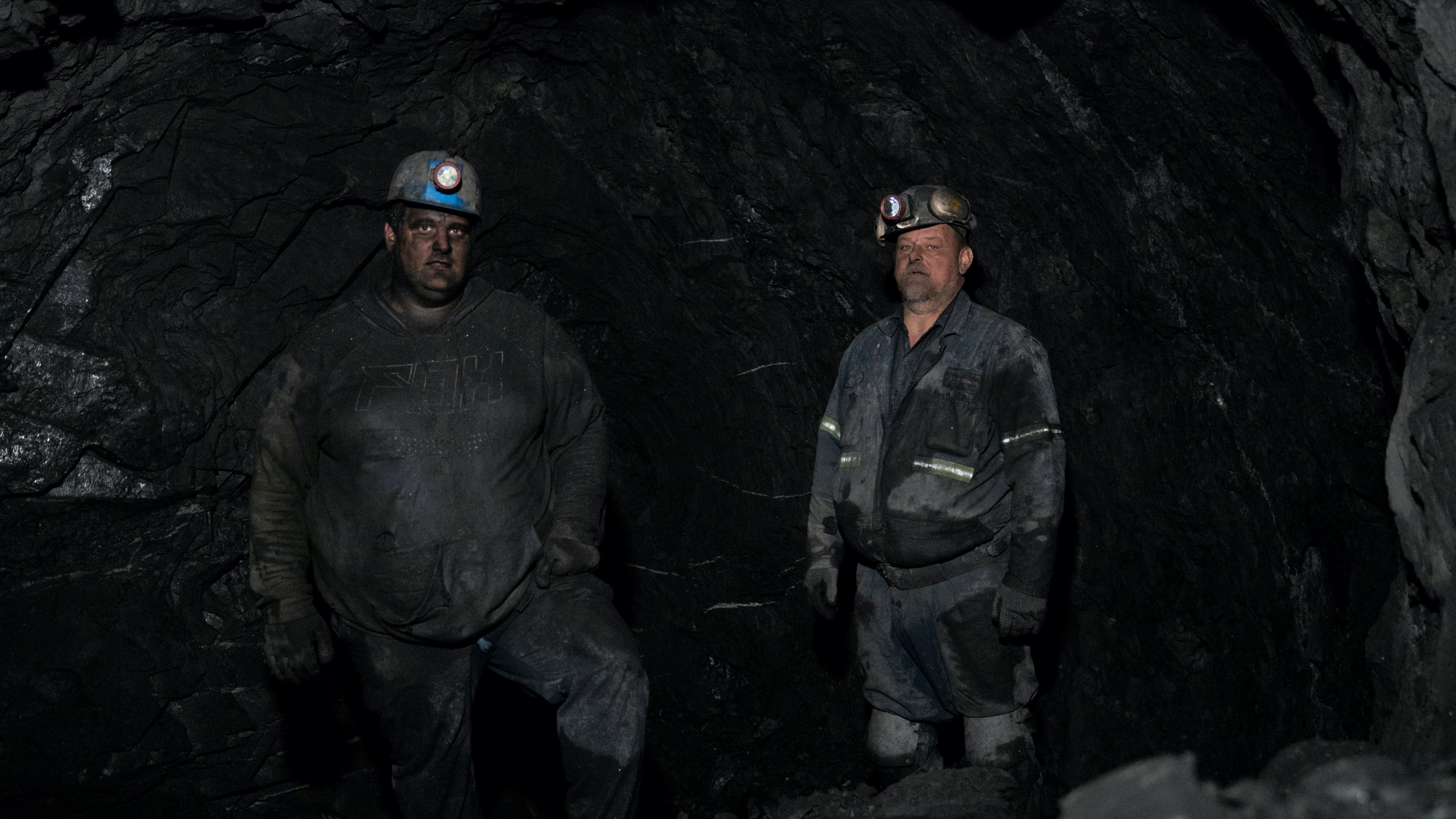 Two coal miners in uniform with skinned blackened from coal mining.