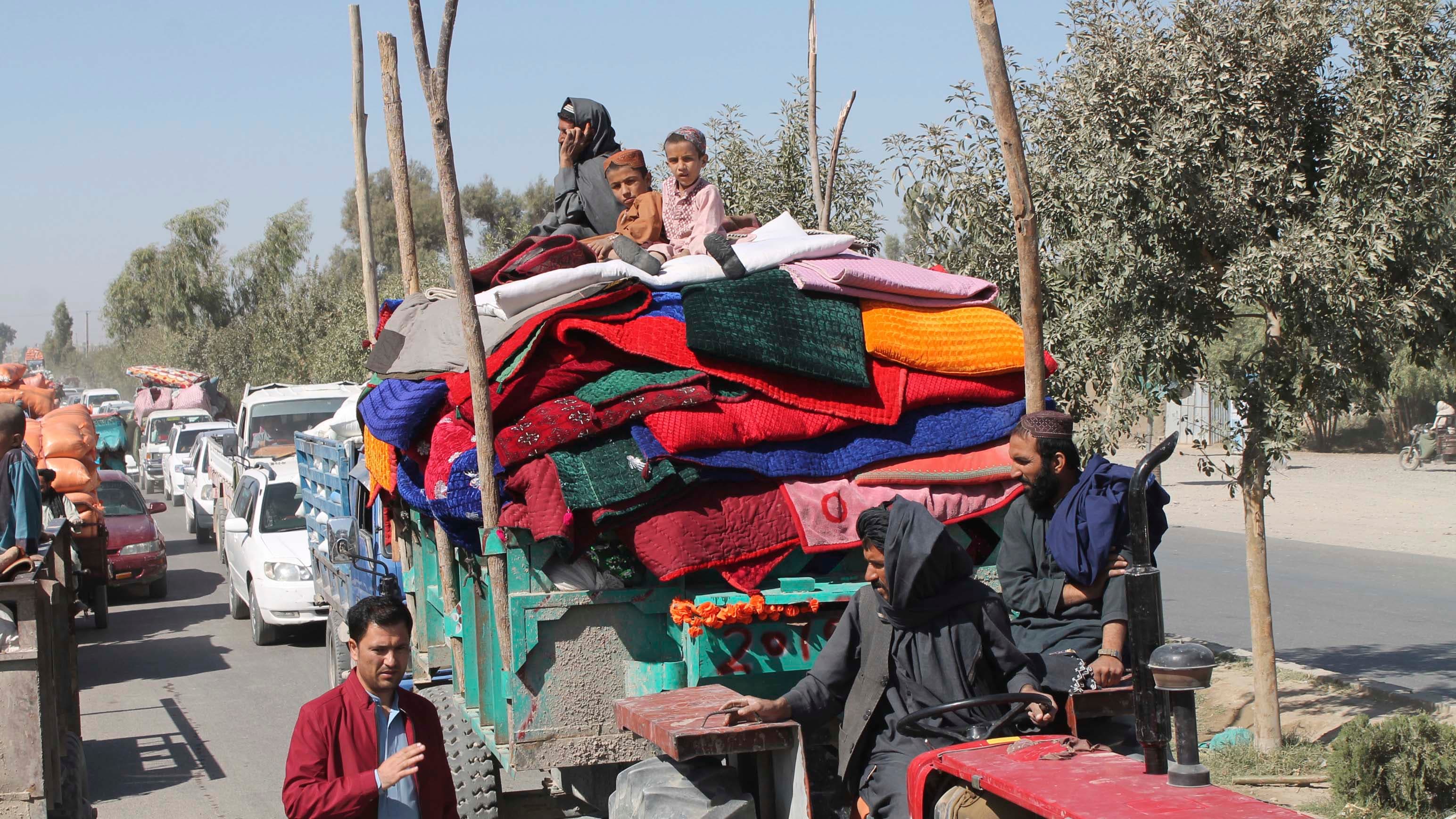 Afghan families leave their houses after fighting between the Afghan military and Taliban insurgents in Helmand province in southern Afghanistan, Oct. 13, 2020.
