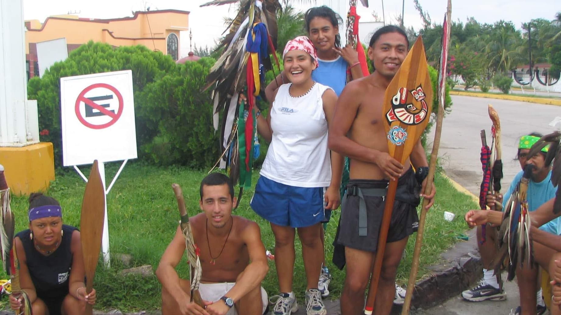 A group of runners carrying staffs and smile for a group shot