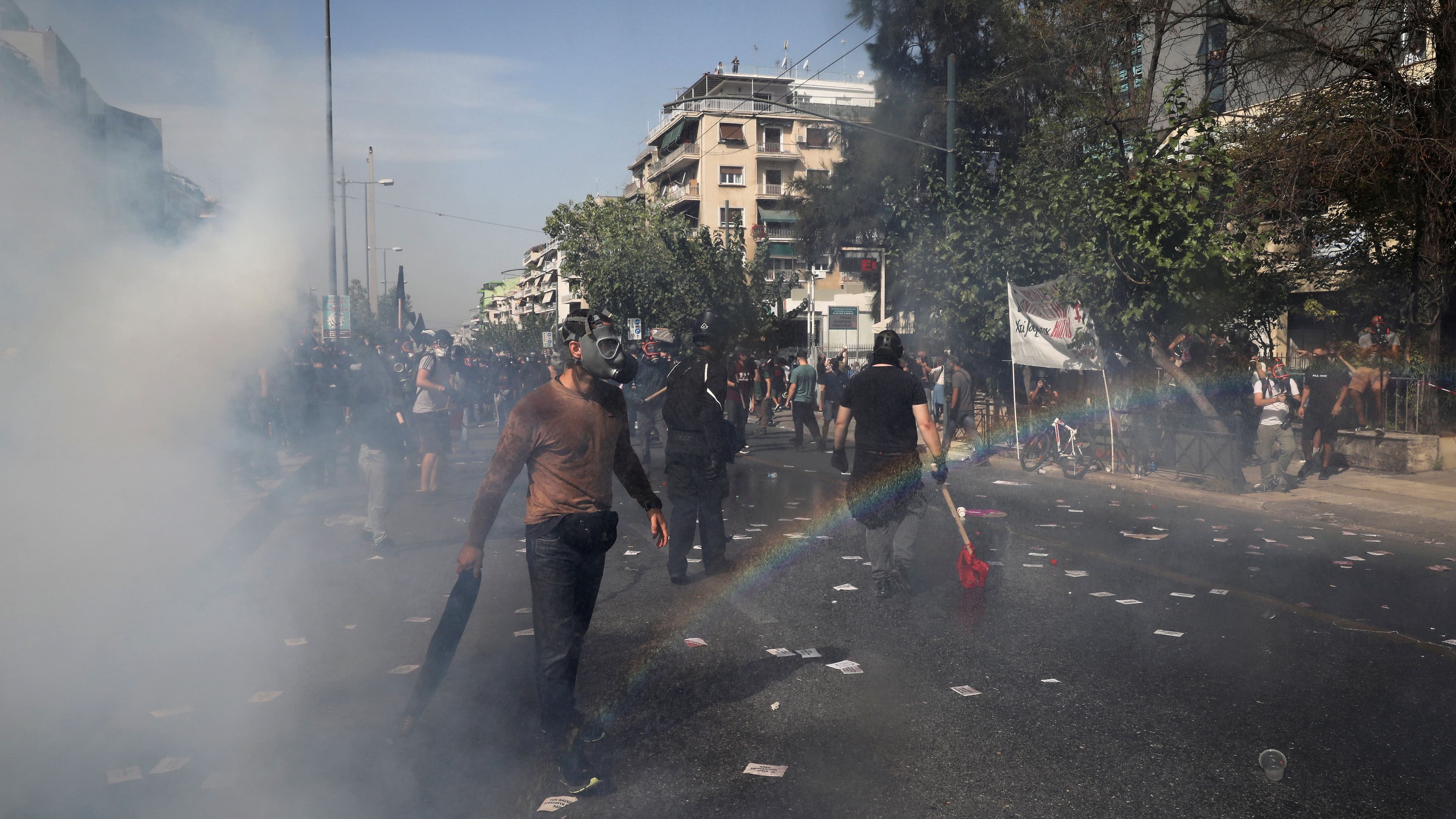 Protesters are seen among tear gas during clashes outside a court, where the trial of leaders and members of the Golden Dawn far-right party takes place in Athens, Greece, Oct. 7, 2020.