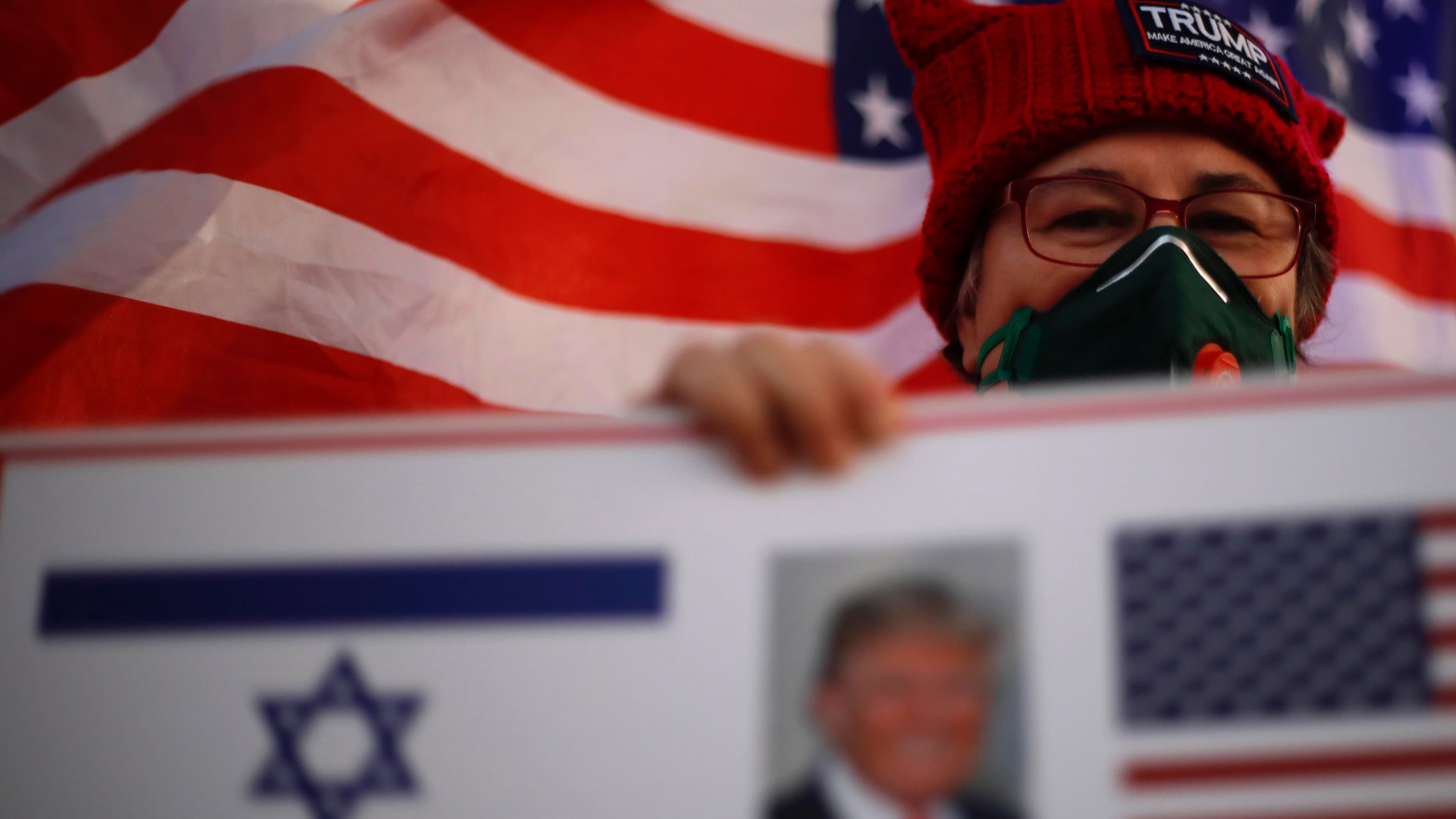 A supporter of US President Donald Trump waves Israeli and US national flags on the day of the U.S. presidential election, in Carmiel, northern Israel, Nov. 3, 2020.