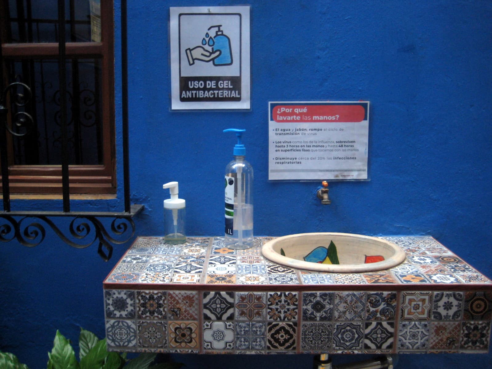 Hygiene station at the entrance of Las Golondrinas Hotel include a sink for hand-washing and a bottle with antibacterial gel.