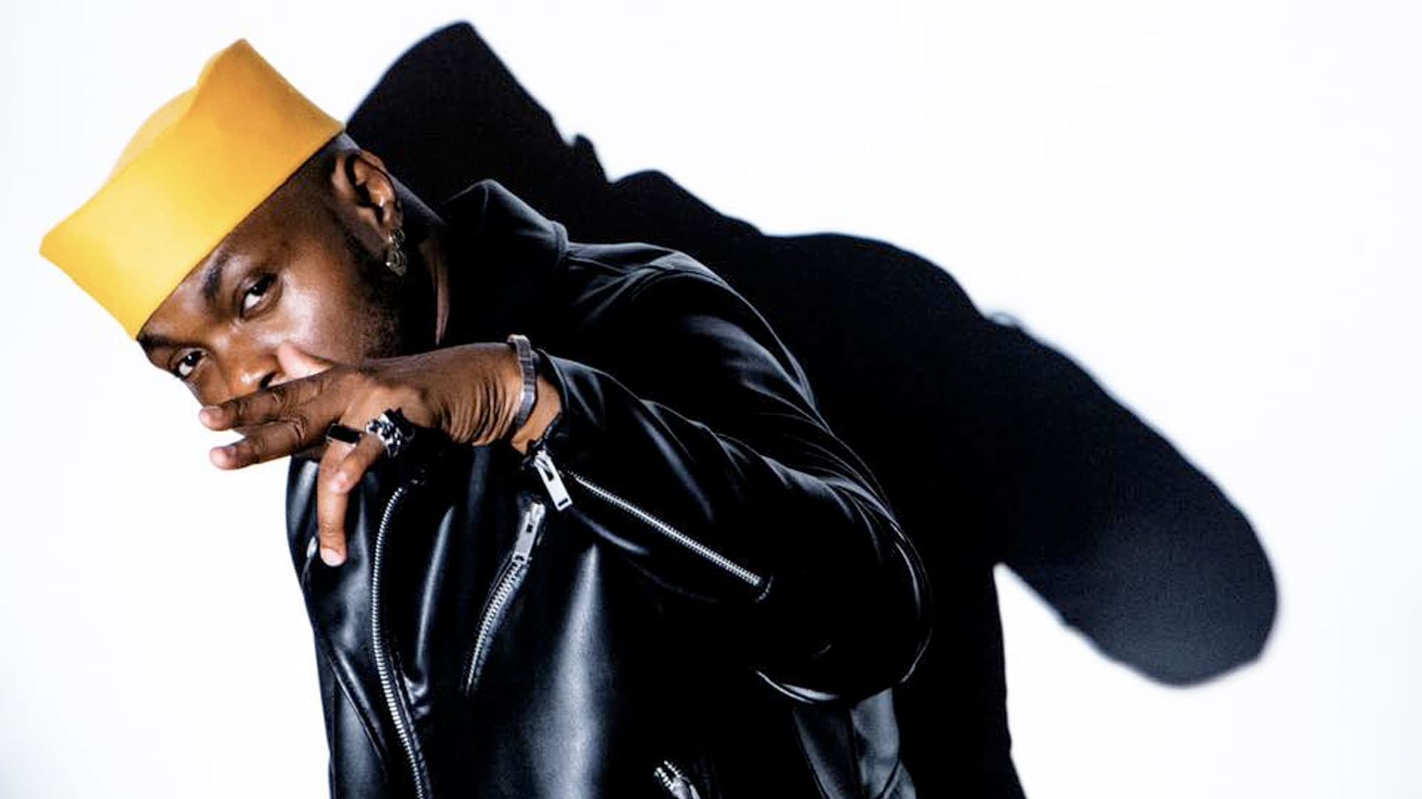 A profile photograph of Shirazee wearing a yellow hat and black leather jacket.