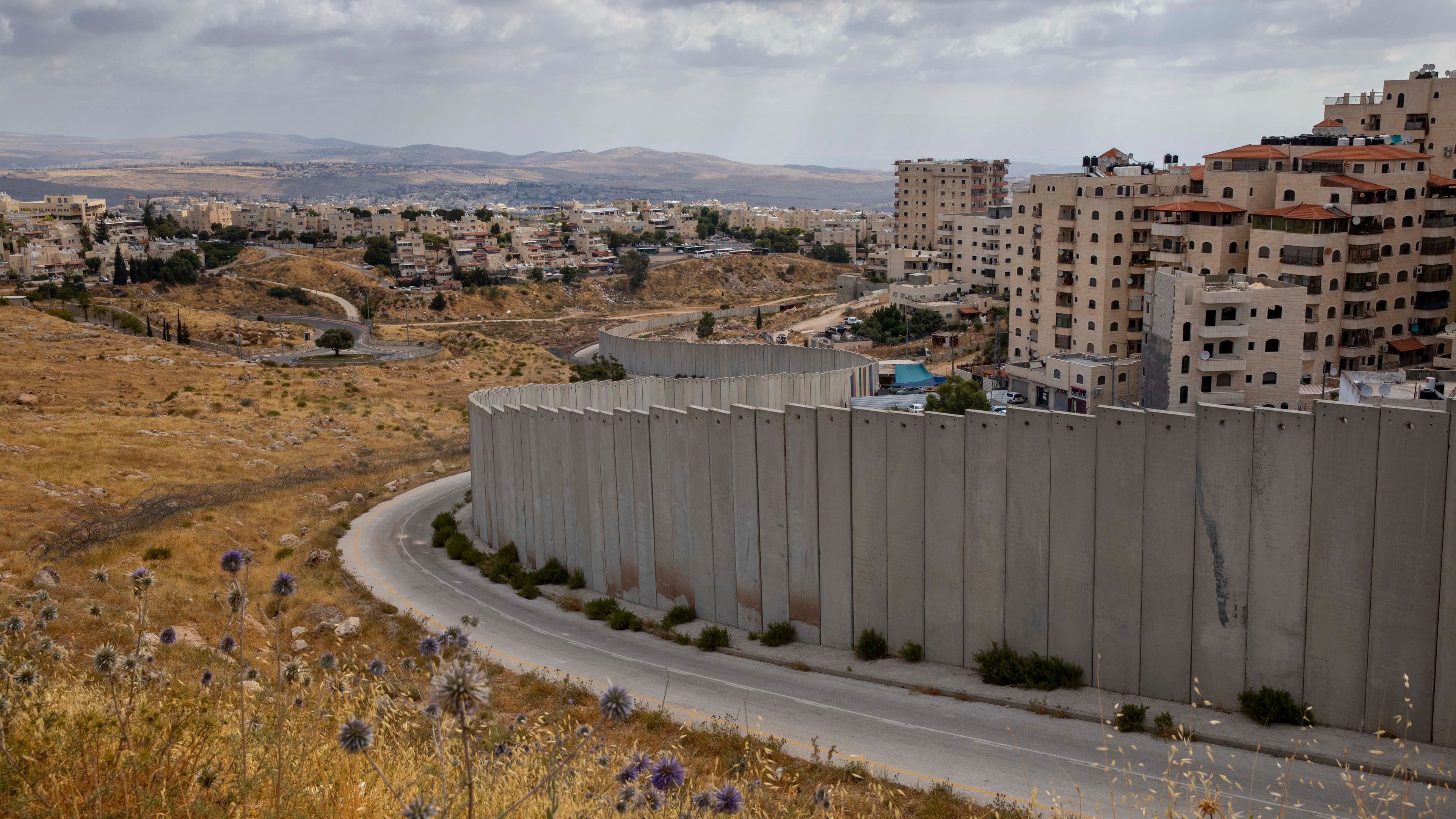 A view of Shuafat refugee camp is seen behind section of Israel's separation barrier in Jerusalem, June 19, 2020.