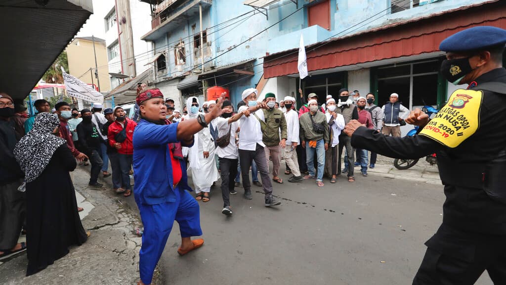 Supporters of Rizieq Shihab, leader of the Islam Defenders Front, confront police officers during a rally in Jakarta, Indonesia, Dec. 18, 2020. Hundreds of protesters marched in Indonesia's capital on Friday to demand the release of the firebrand cleric w