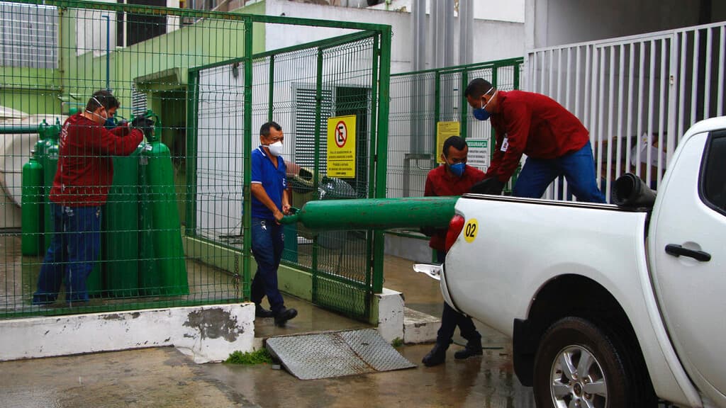 Amazonas Federal University's workers carry empty oxygen tanks at the Getulio Vargas Hospital amid the new coronavirus pandemic, Manaus, Brazil, Thursday, Jan. 14, 2021. Scores of COVID-19 patients in the Amazon rainforest's biggest city will be transferr