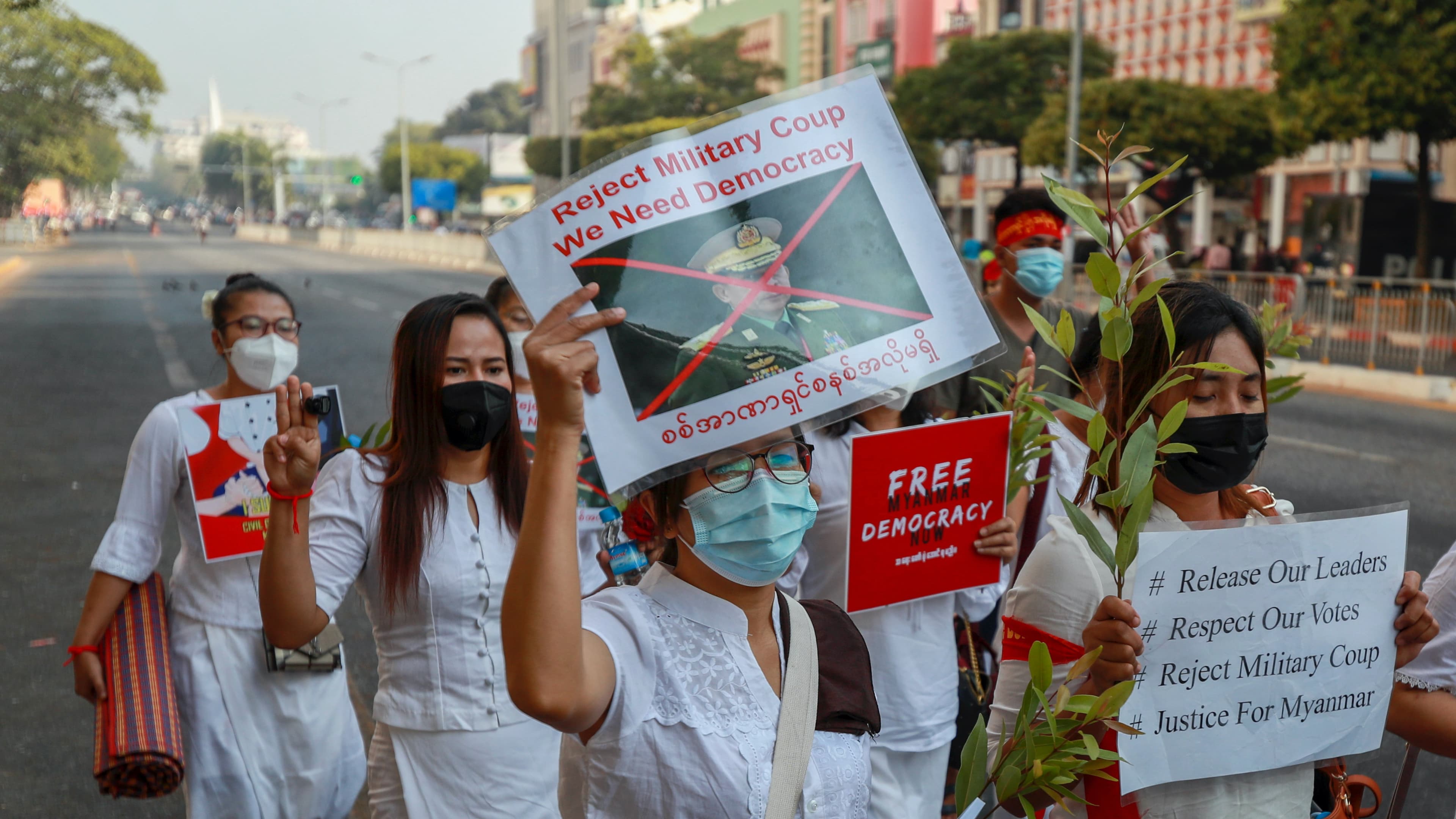 A demonstrator displays a picture of the defaced image of the commander in chief, Senior Gen. Min Aung Hlaing, also chairman of the State Administrative Council to protest against the military coup in Yangon, Myanmar, Feb. 17, 2021. The UN expert on human