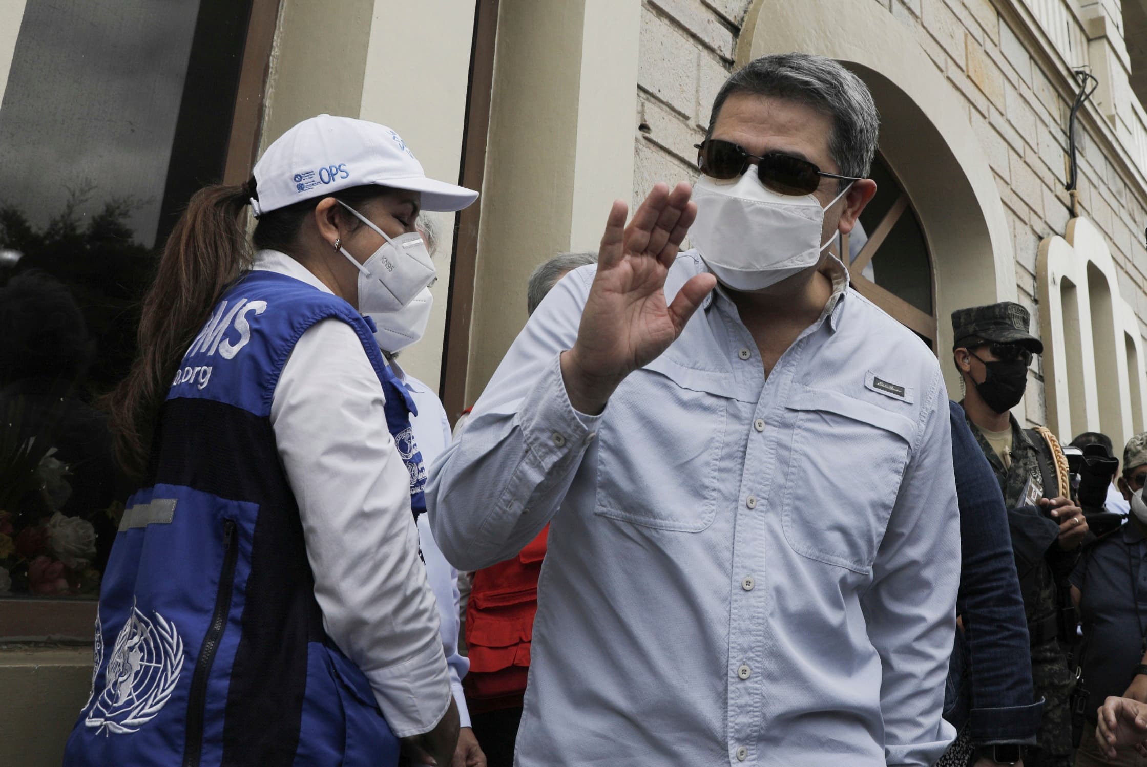 Honduran President Juan Orlando Hernandez waves upon his arrival to an air base to receive a shipment of the AstraZeneca COVID-19 vaccine via the COVAX program, in Tegucigalpa, Honduras, March 13, 2021.