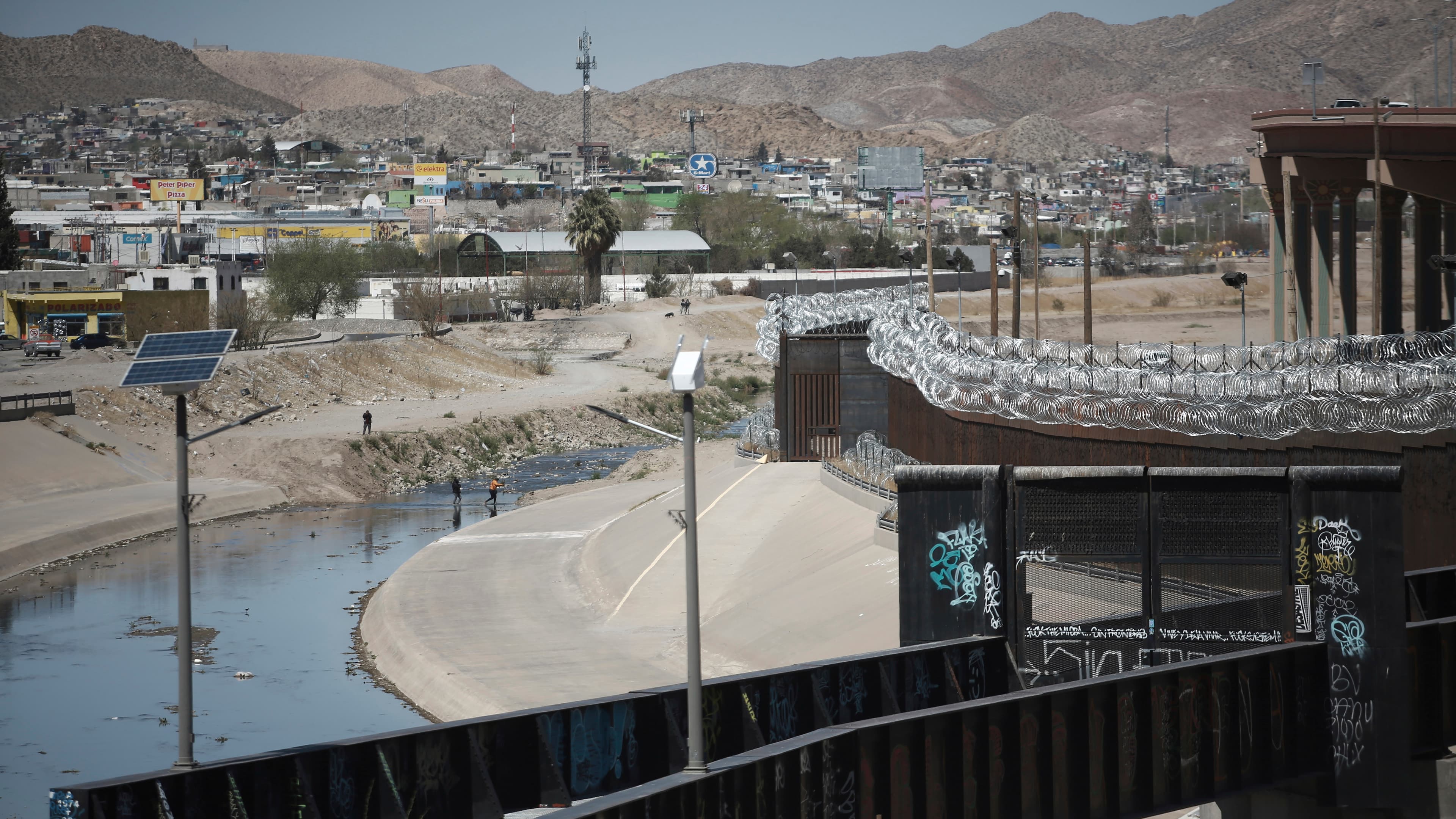 People cross the border between US and Mexico