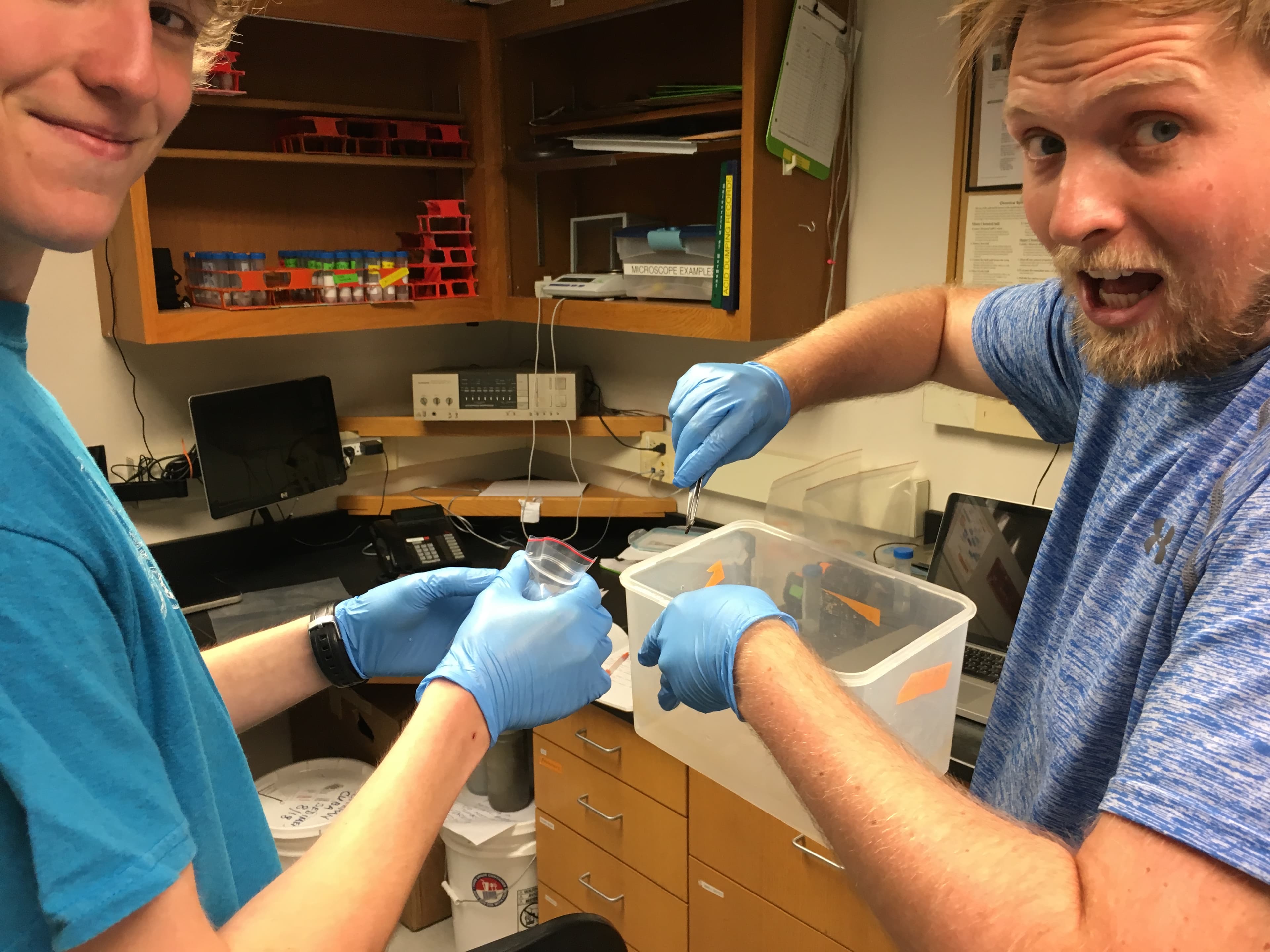 Glacial geomorphologist Andrew Christ (right), with geology student Landon Williamson, holds up the first twig spotted as they washed a sediment sample from Camp Century.