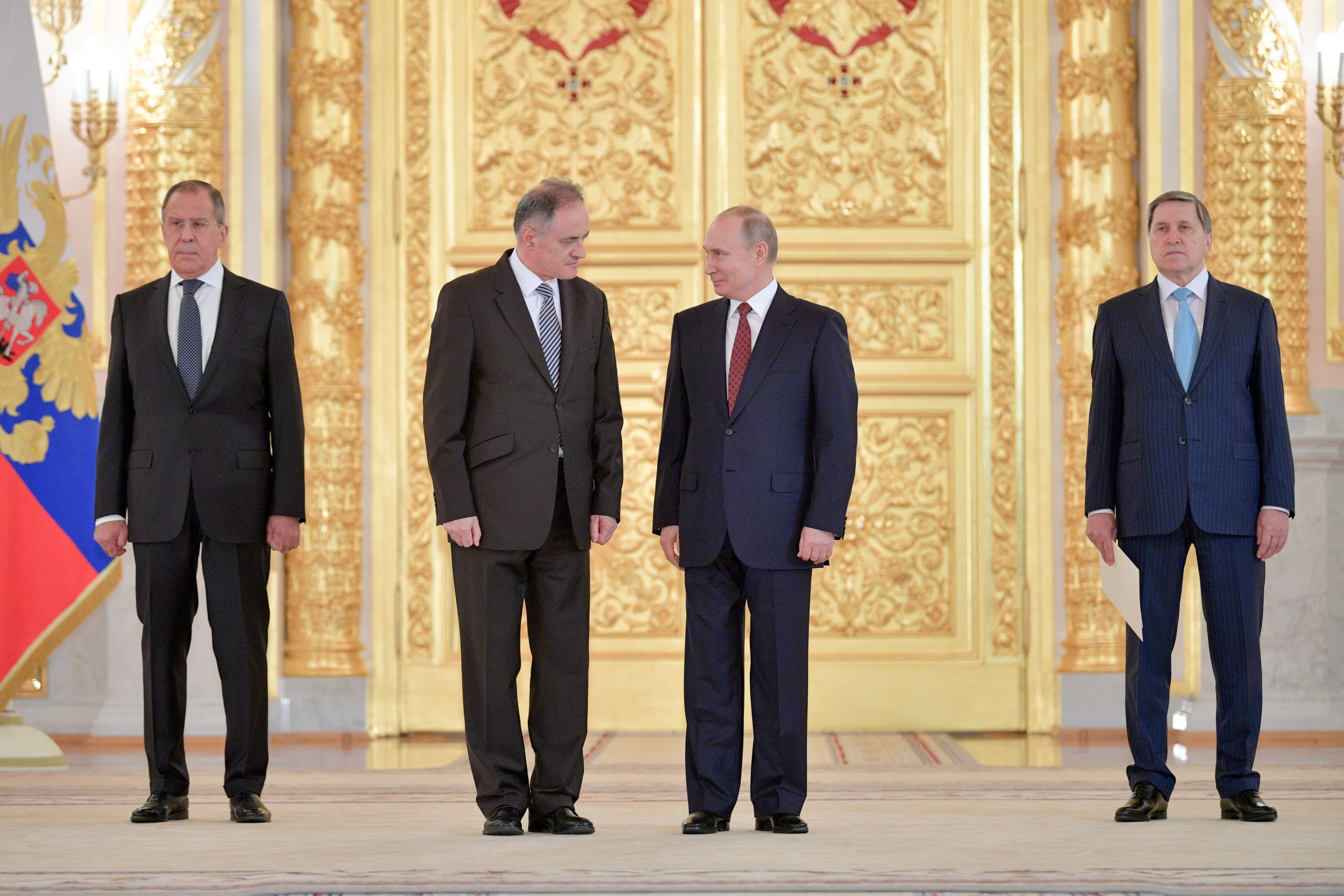 Four men stand in a line – the two in the middle at Montenegro's ambassador to Russia and Vladimir Putin