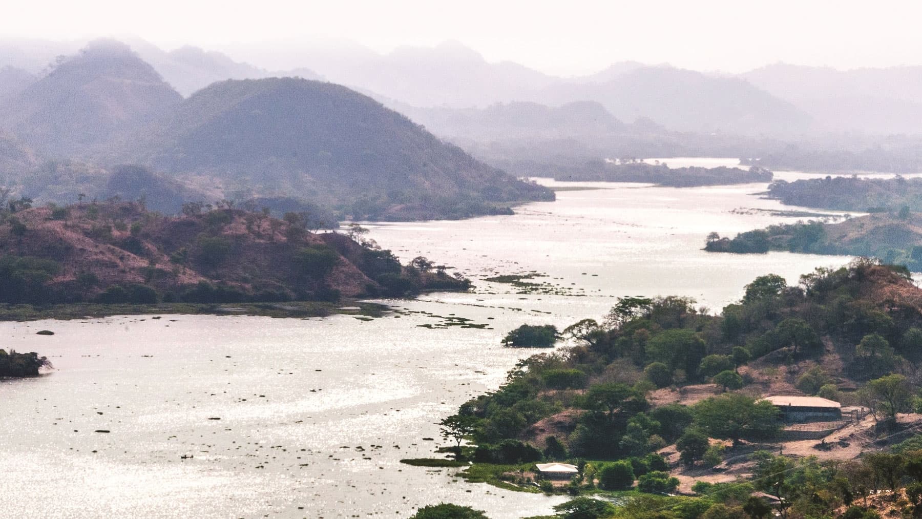 A large scenic river with sloping mountains on either side.
