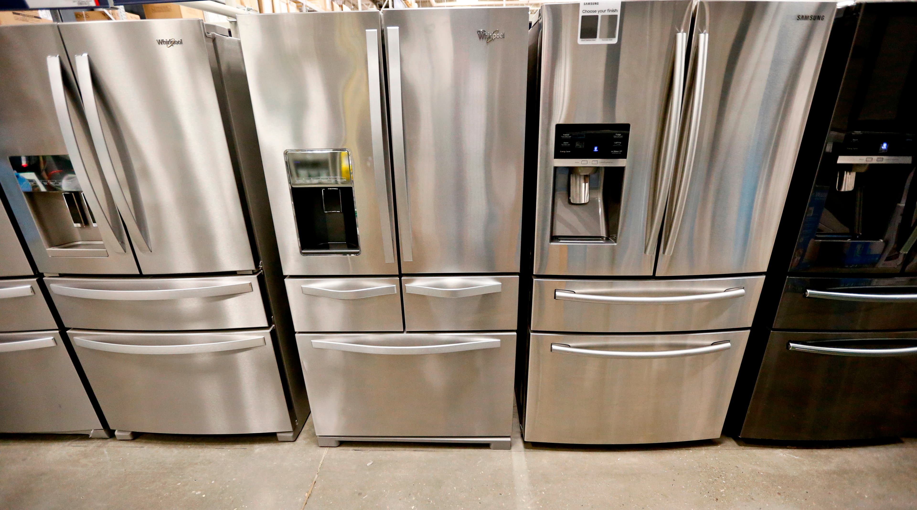 A selection of silver refrigerators on display at an appliance store.