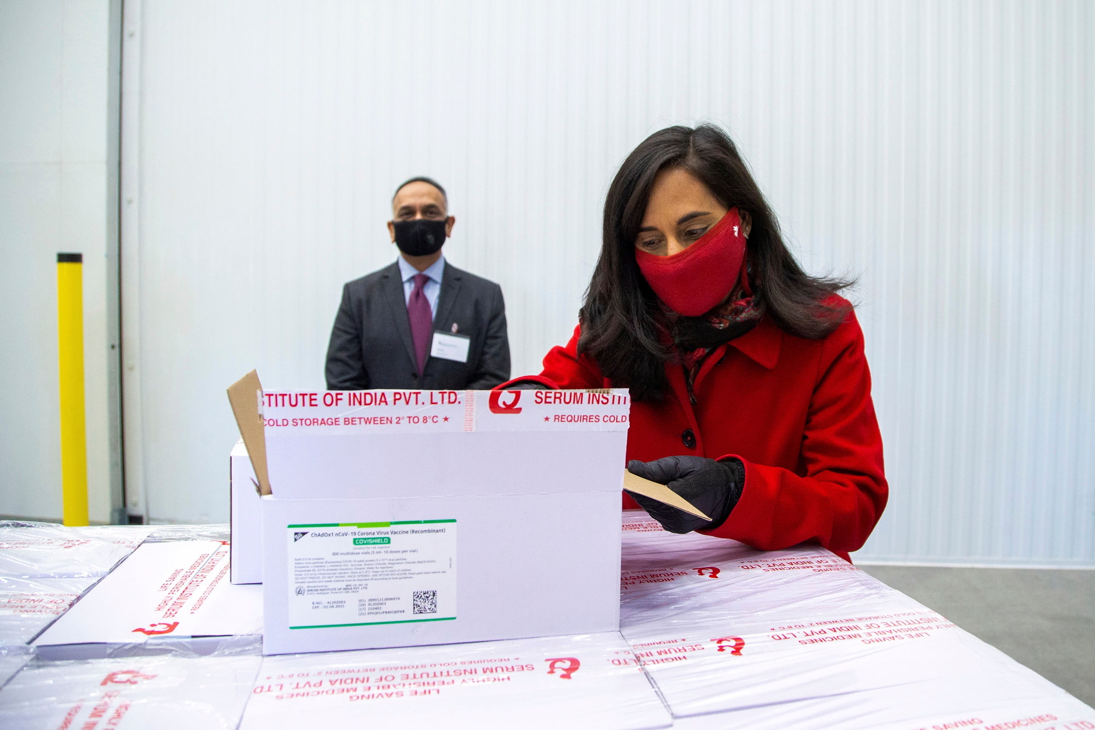 Anita Anand, Canada's Minister of Public Services and Procurement opens a box with some of the AstraZeneca COVID-19 vaccine doses that Canada has secured through a deal with the Serum Institute of India in partnership with Verity Pharma at a facility in M