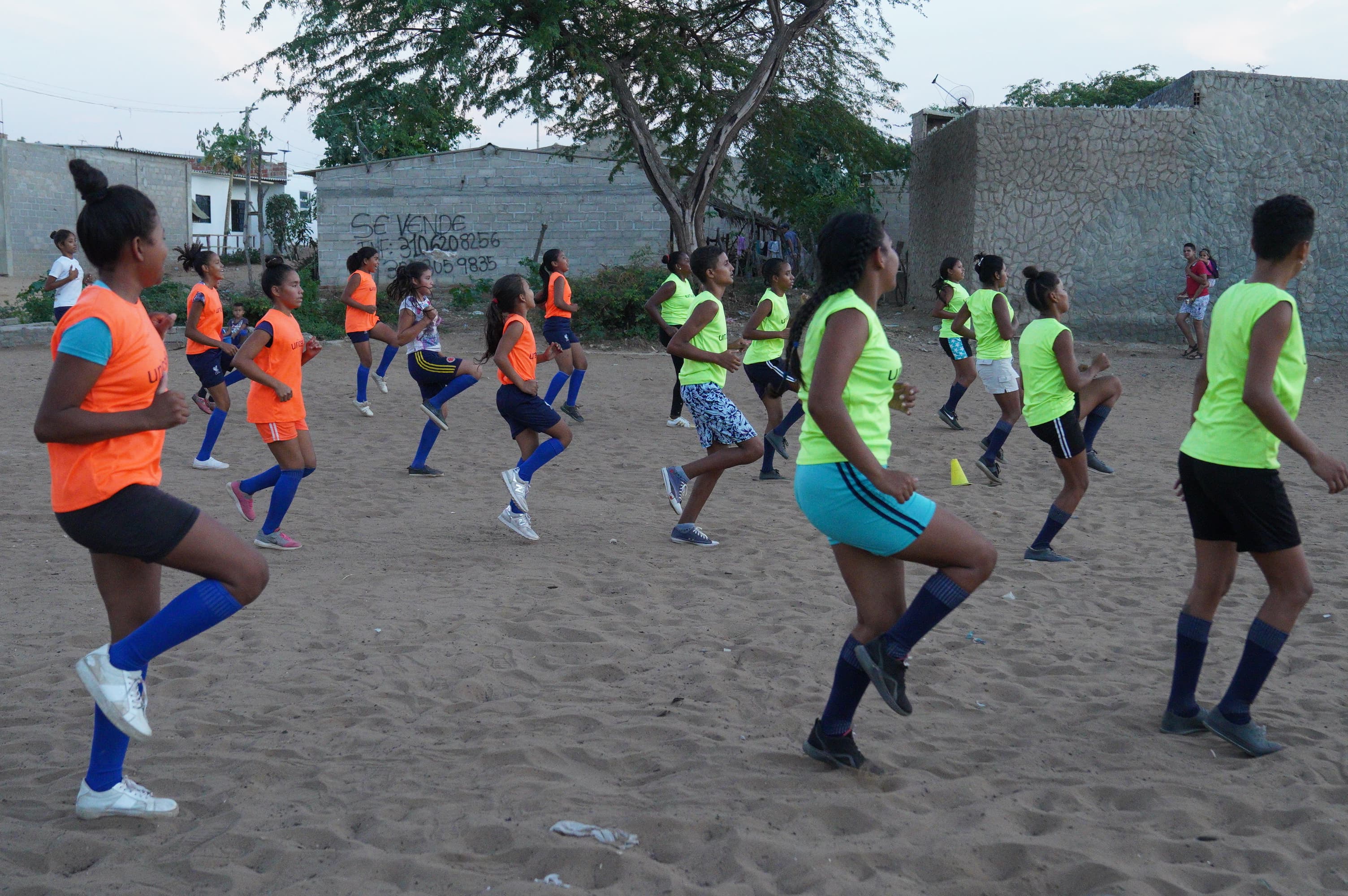 Kickball players in the Brisas del Norte neighborhood do a warm up drill before a match. The league is open to children and adults. 