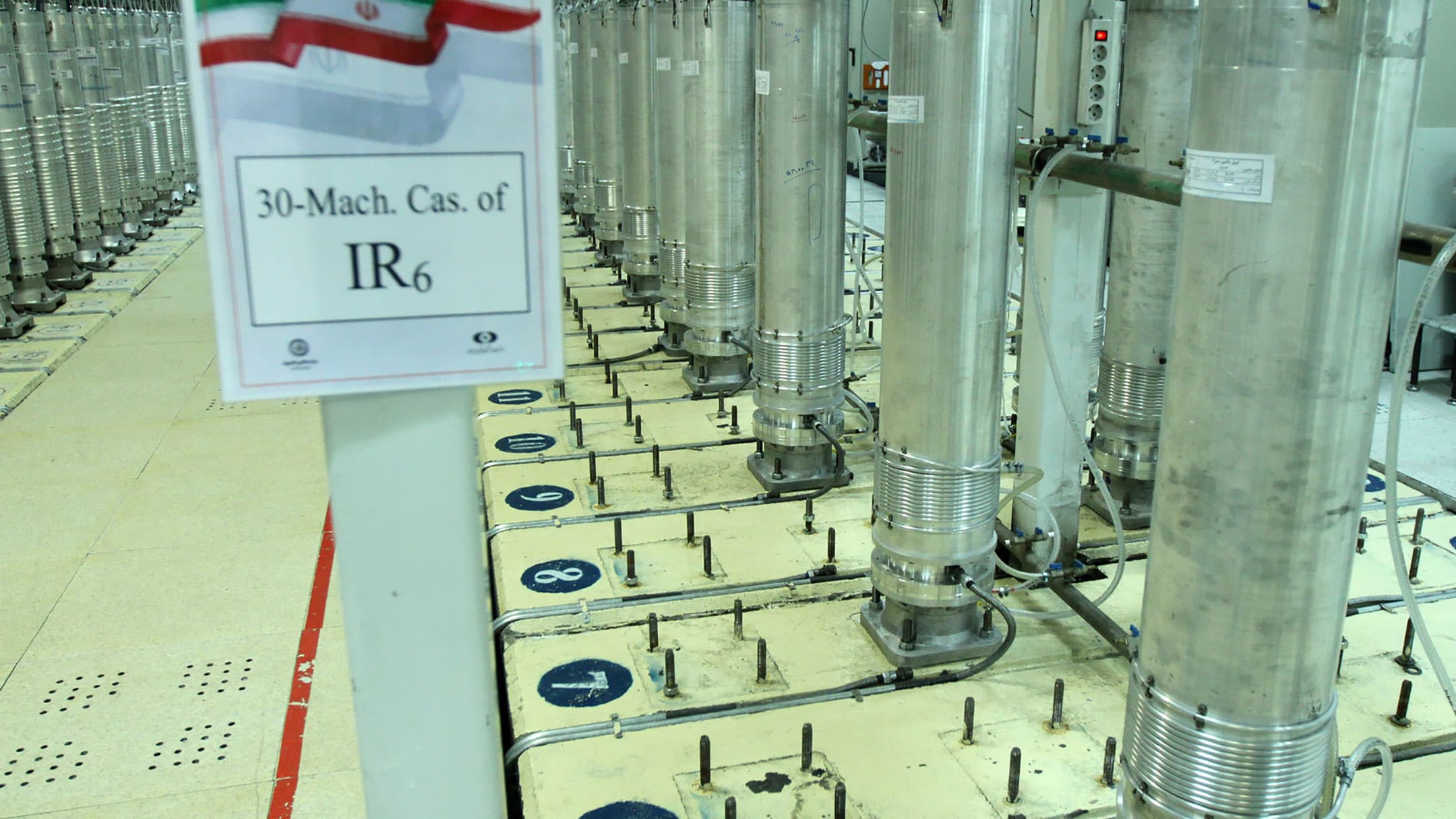 A row of tall stainless steel centrifuges are shown.