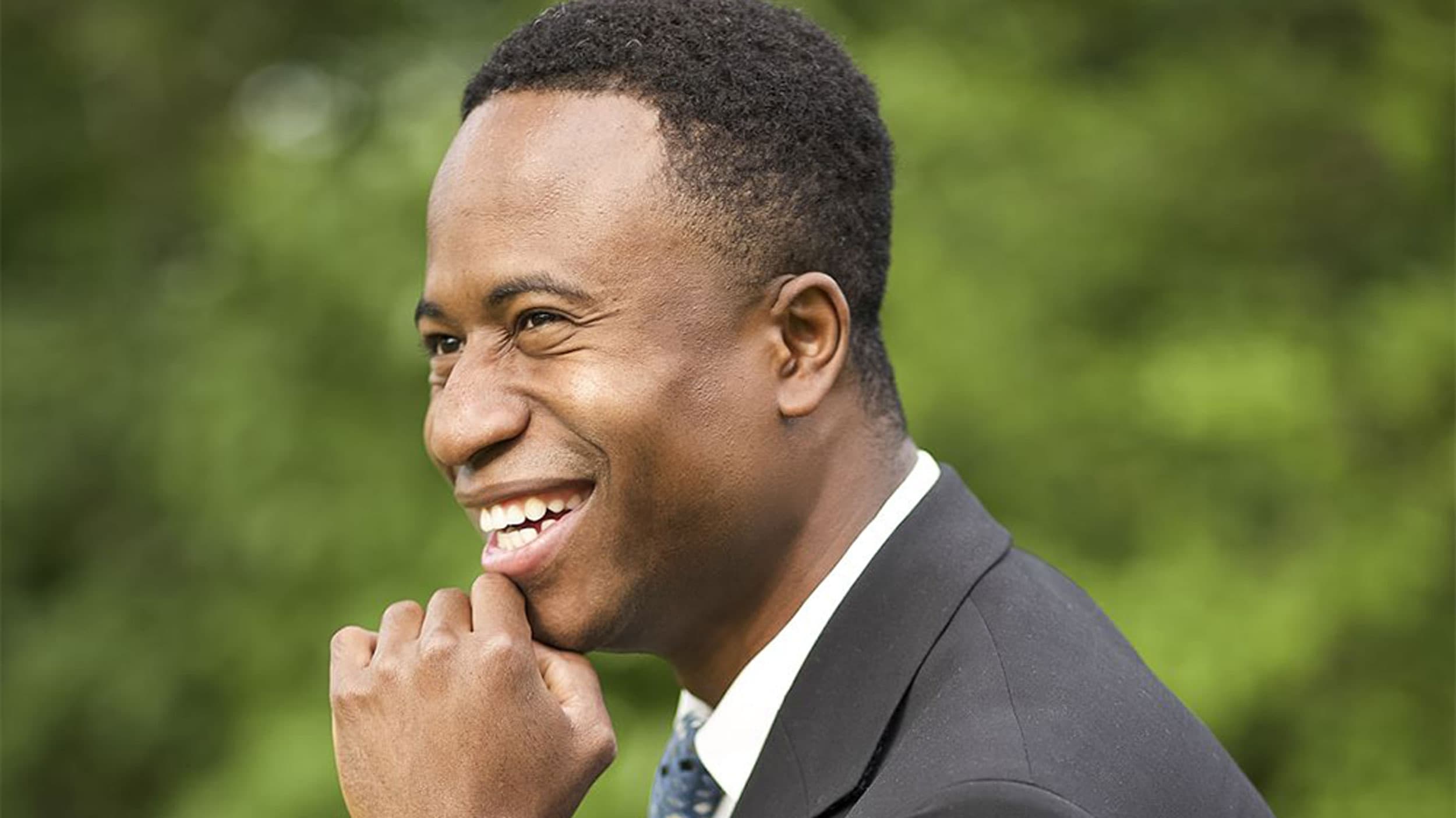 African American Mayor Mike Elliott poses in a dark gray suit