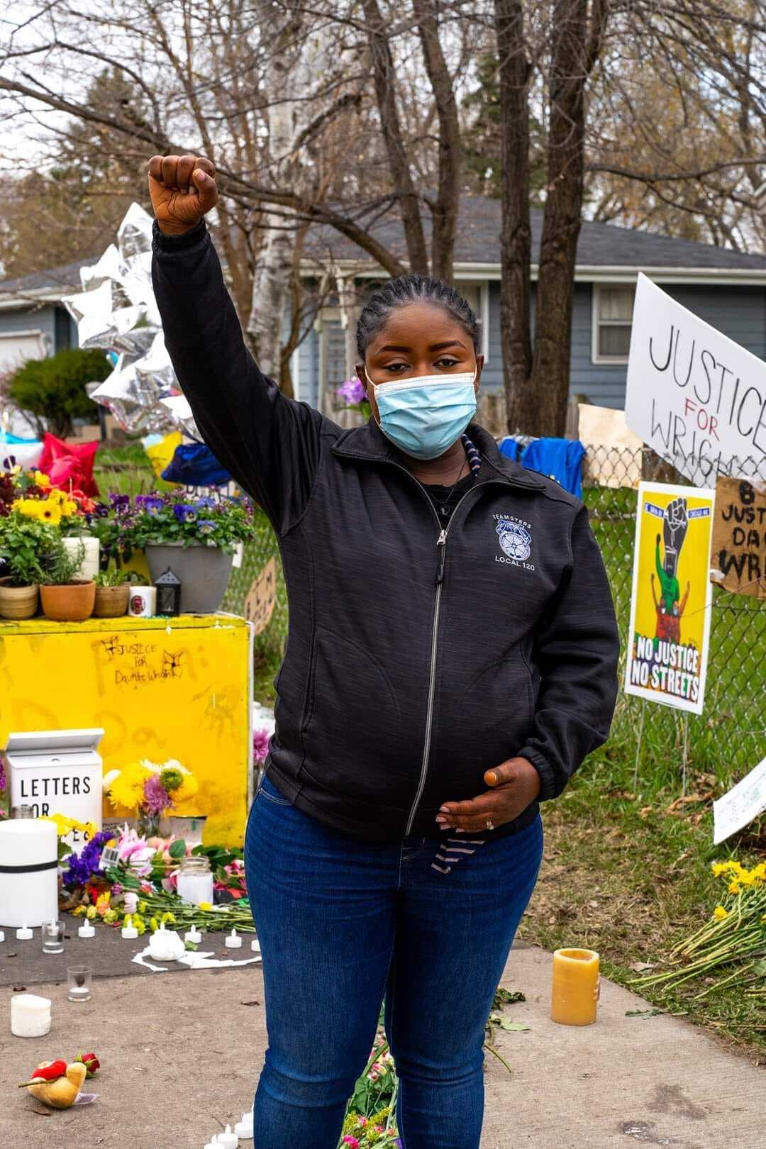 Alfreda Daniels Juasemai, a community organizer, holds a fist up in the air.