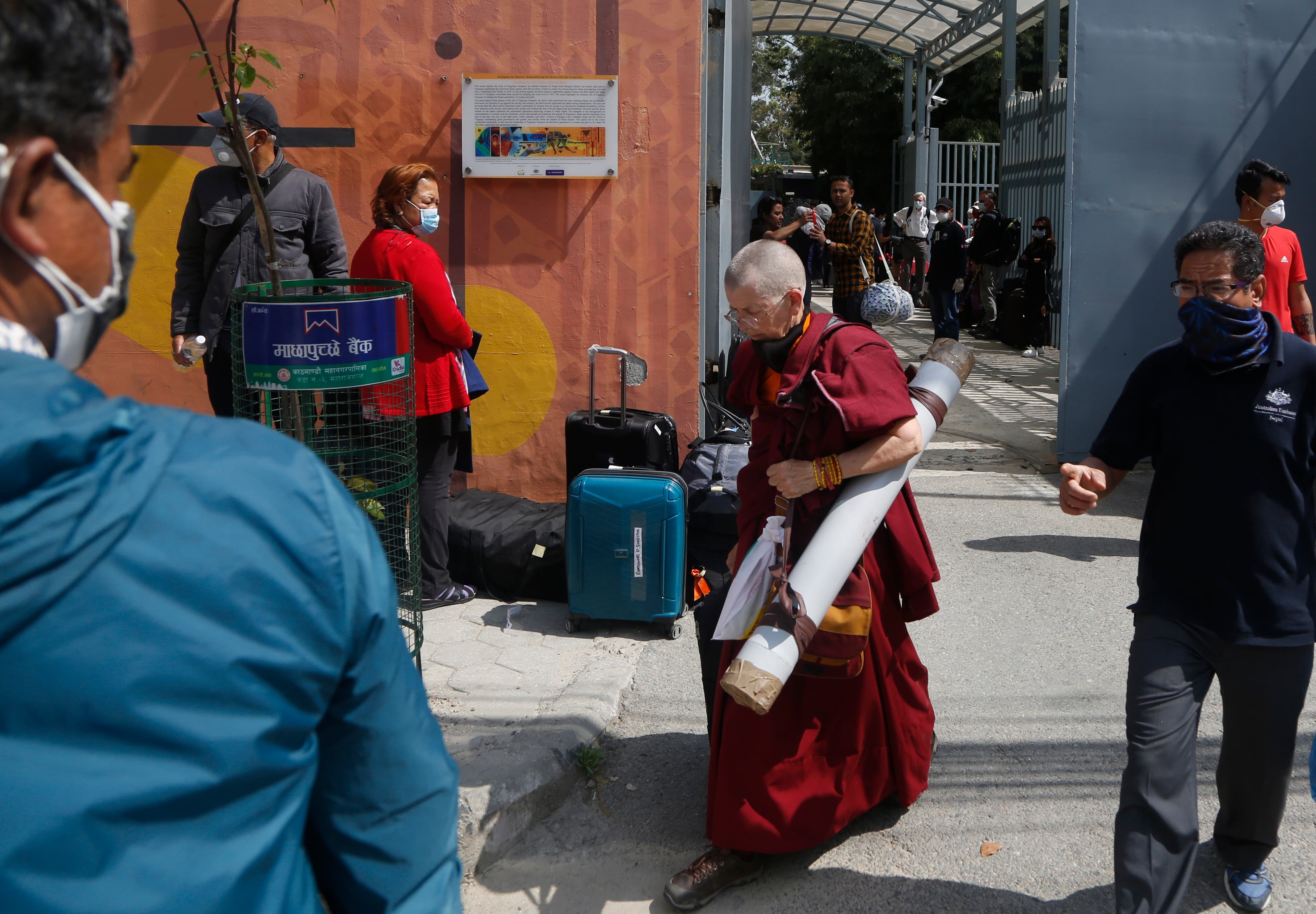 Stranded Australian citizens arrive to catch a bus to take a rescue flight from Tribhuvan International Airport in Kathmandu, Nepal, April 1, 2020. Stranded tourists from Australia and New Zealand boarded a chartered flight out of Nepal Wednesday. The Nep