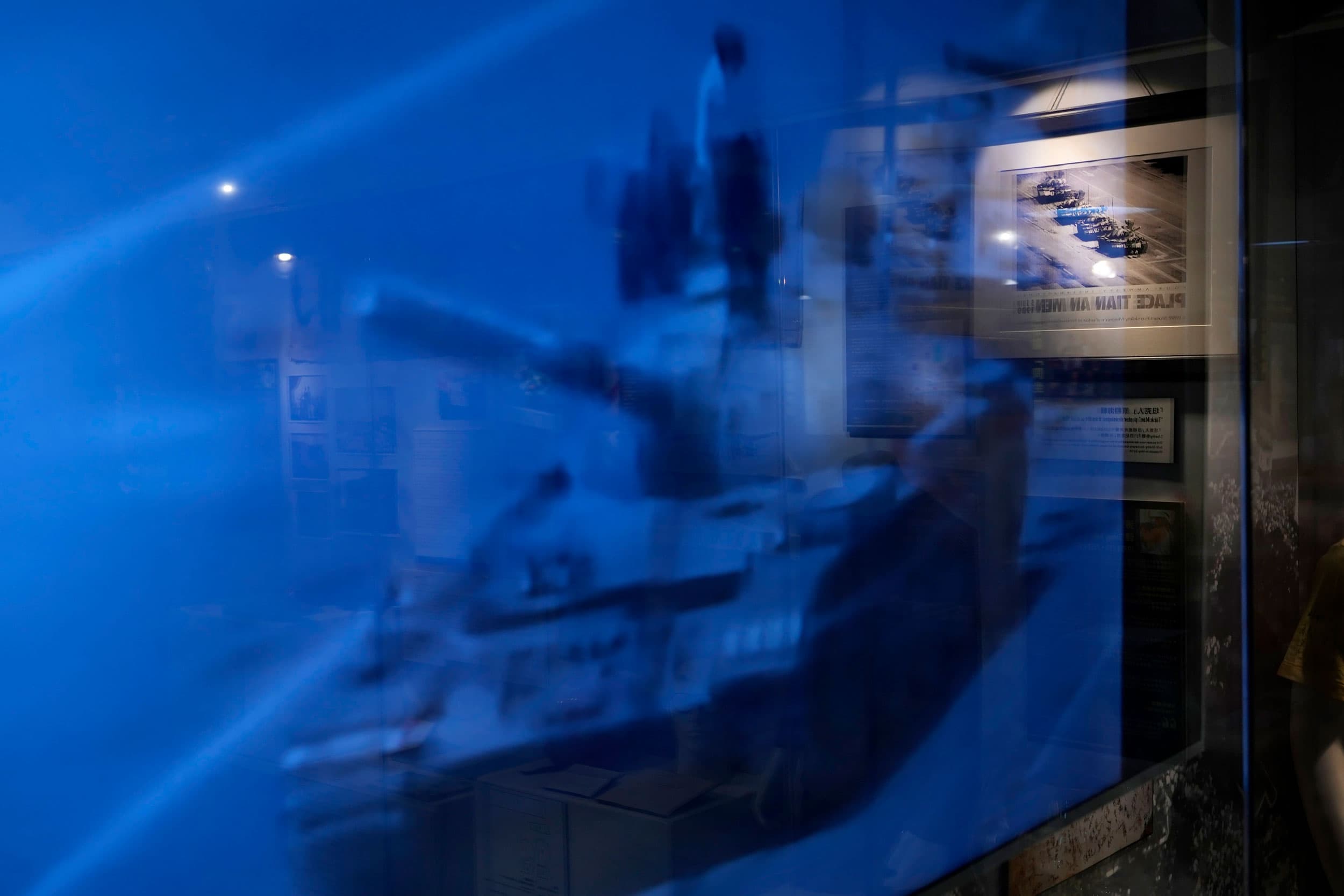A blue color screen shows a man standing on top of a tank.