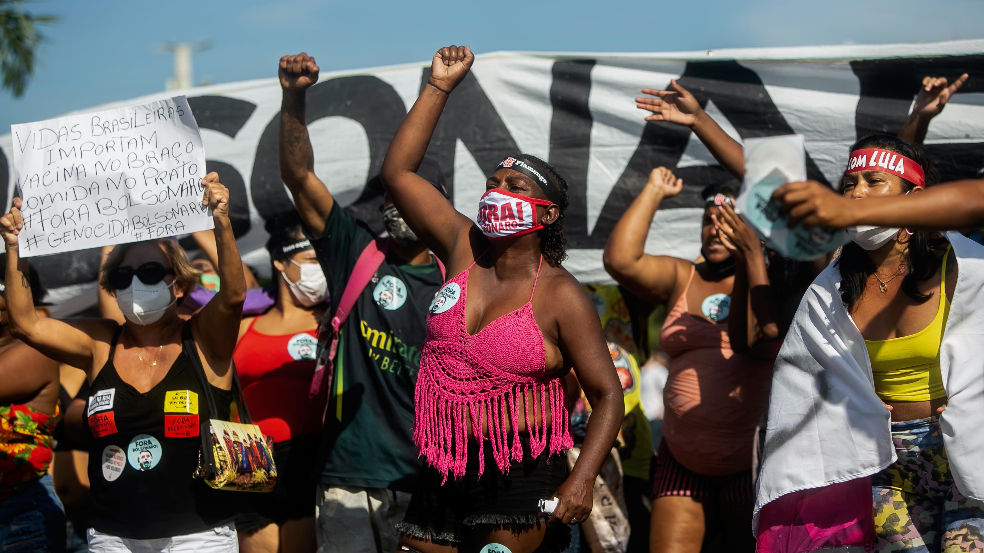 Demonstrators in front of a banner holding their fists up in the air