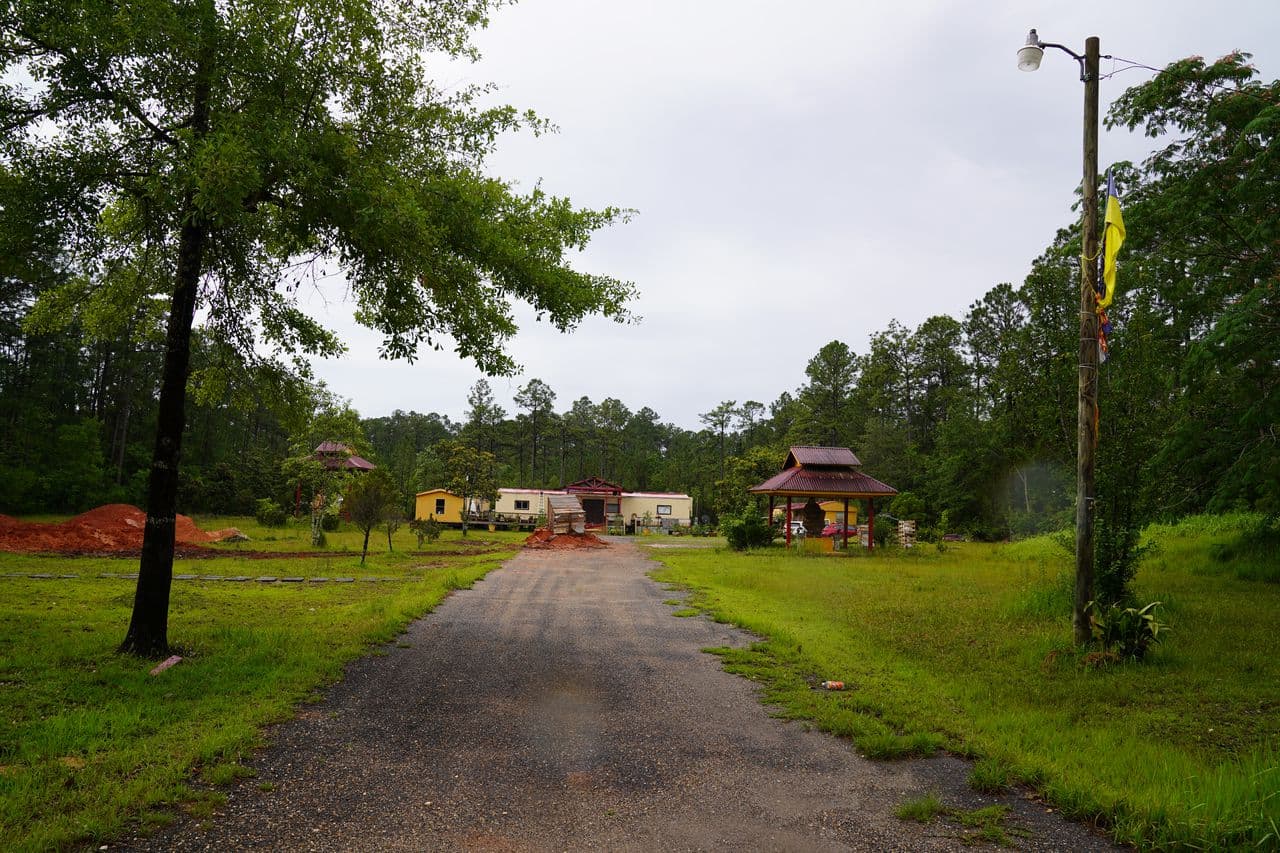A temple in the distance between green lawns and trees