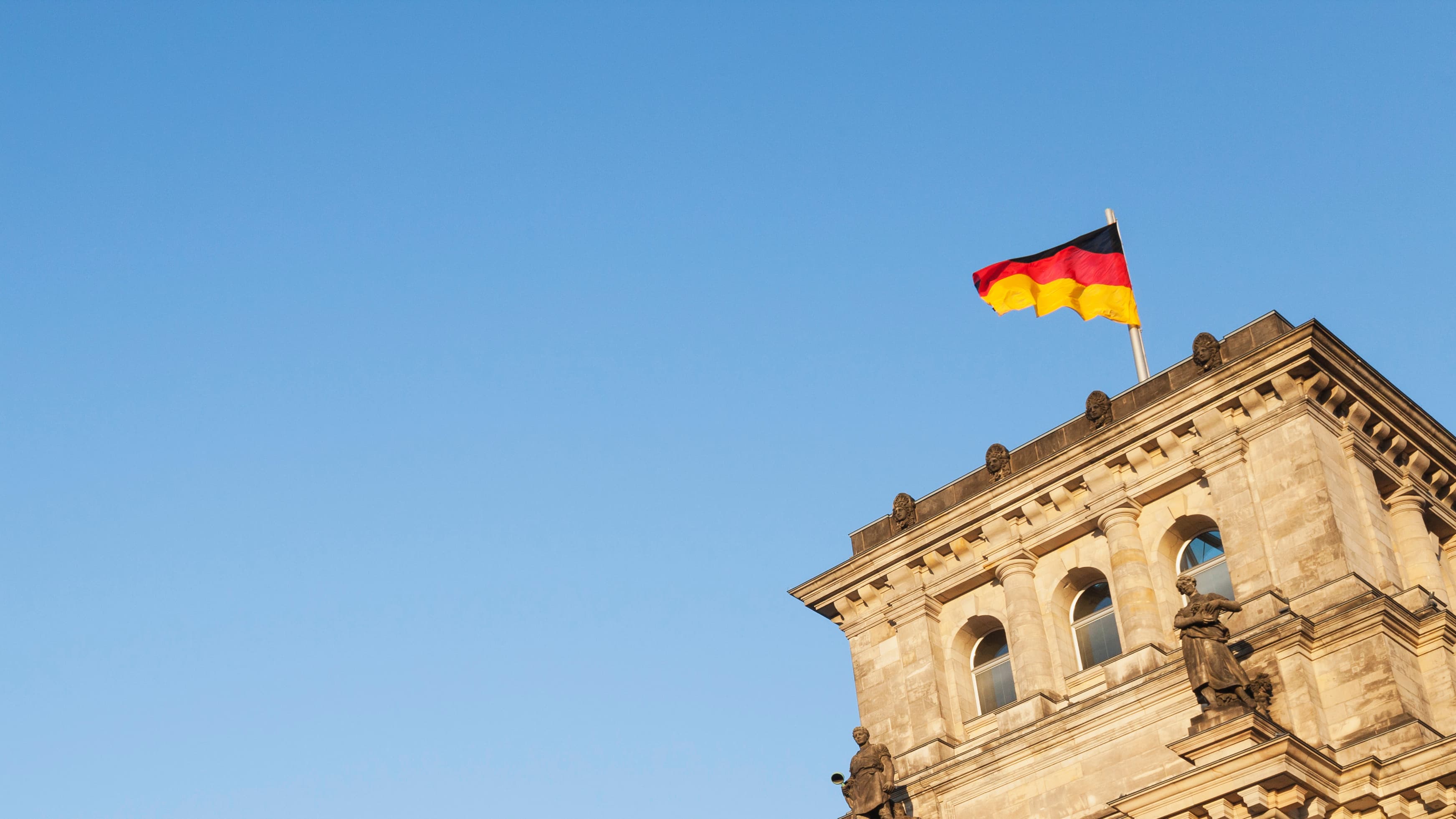 Black, red and yellow German flag waves on top of a building