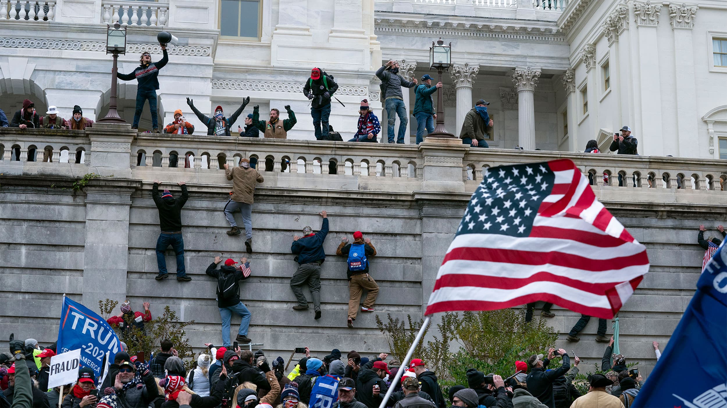 Supporters of President Donald Trump climb the West wall of the the US Capitol in Washington