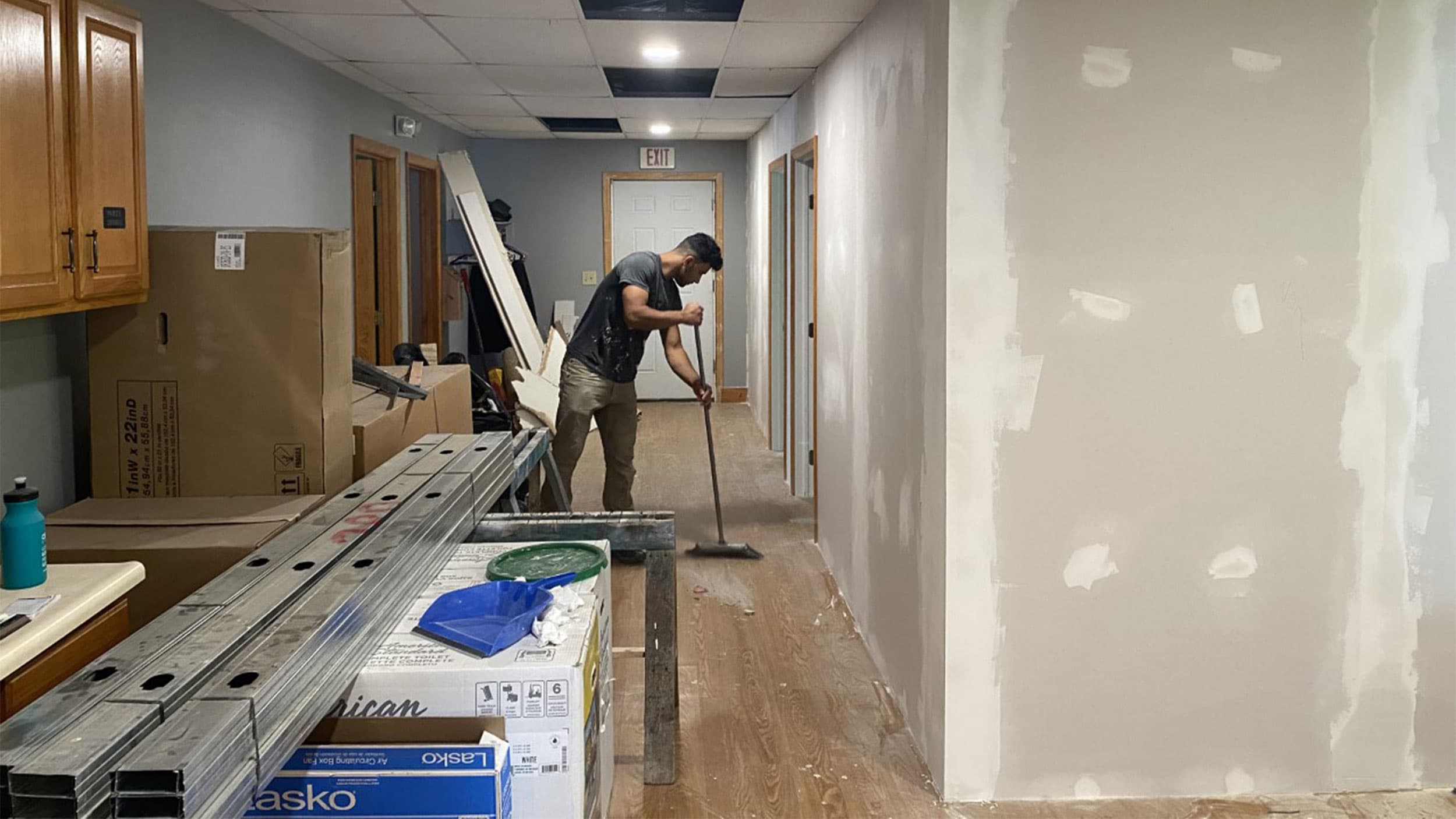 A man sweeps the floor in a church being turned into an apartment