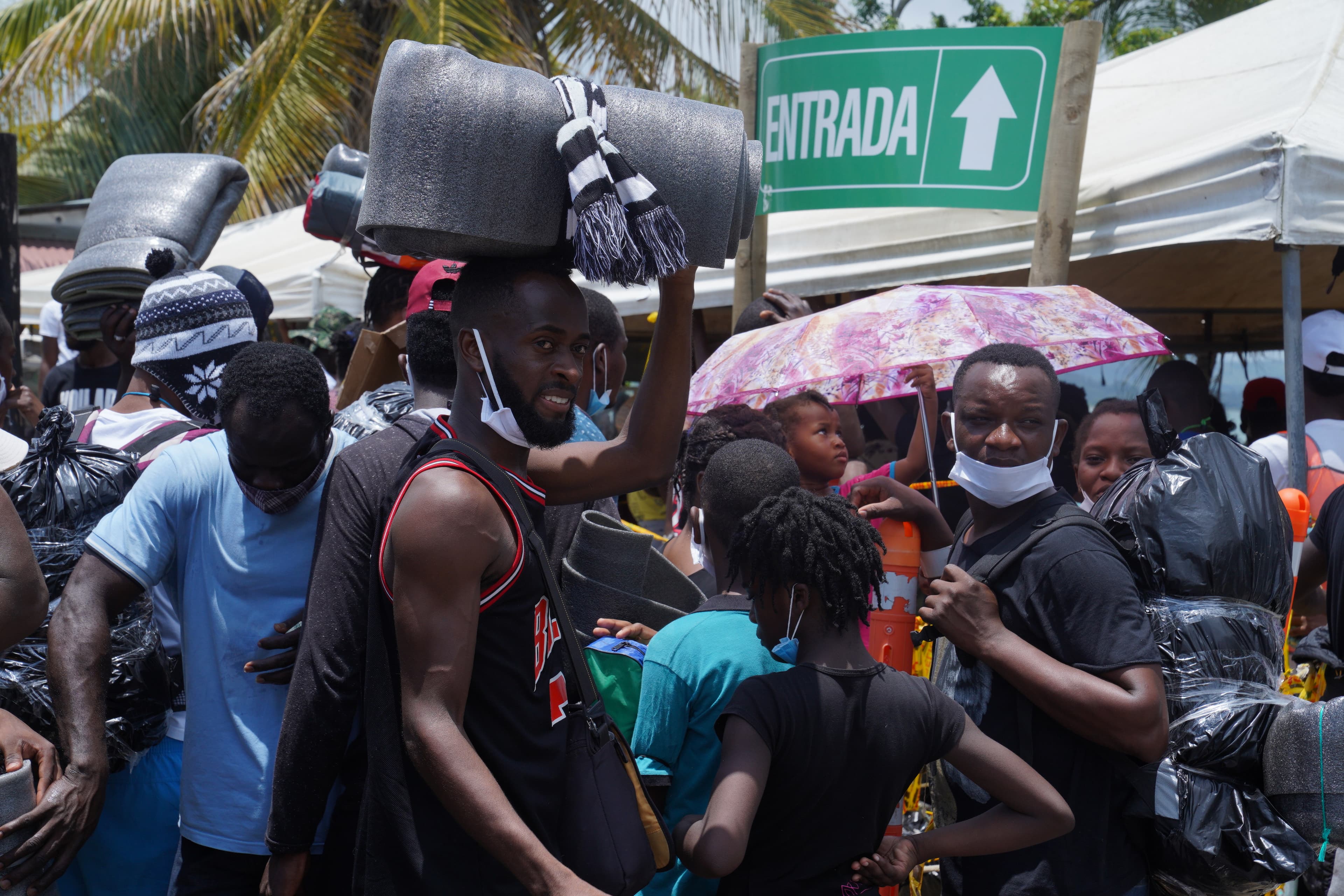 US bound migrants carry foam mattresses and wrap their luggage in garbage bags sealed with tape