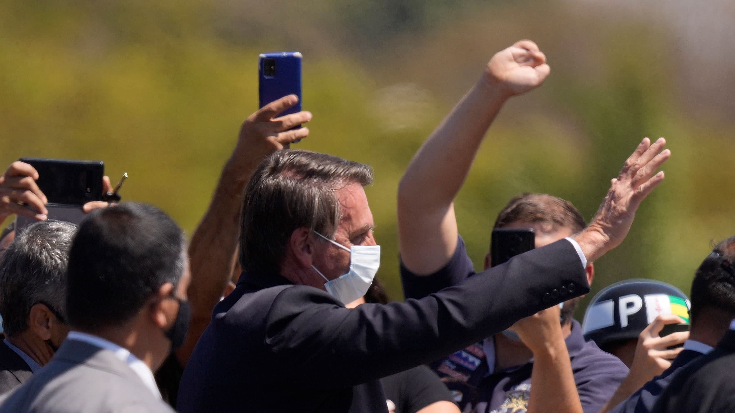 Brazilian President Jair Bolsonaro waves to people during a ceremony marking Soldier Day at Army headquarters in Brasilia, Brazil, Aug. 25, 2021. 