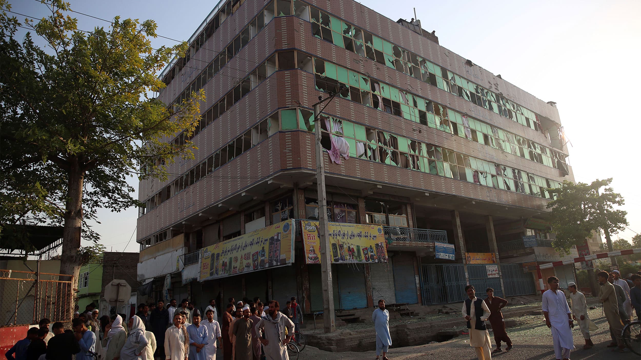 Afghan people are seen near the building where insurgents were hiding during an attack to the prison in the city of Jalalabad, east of Kabul, Afghanistan.