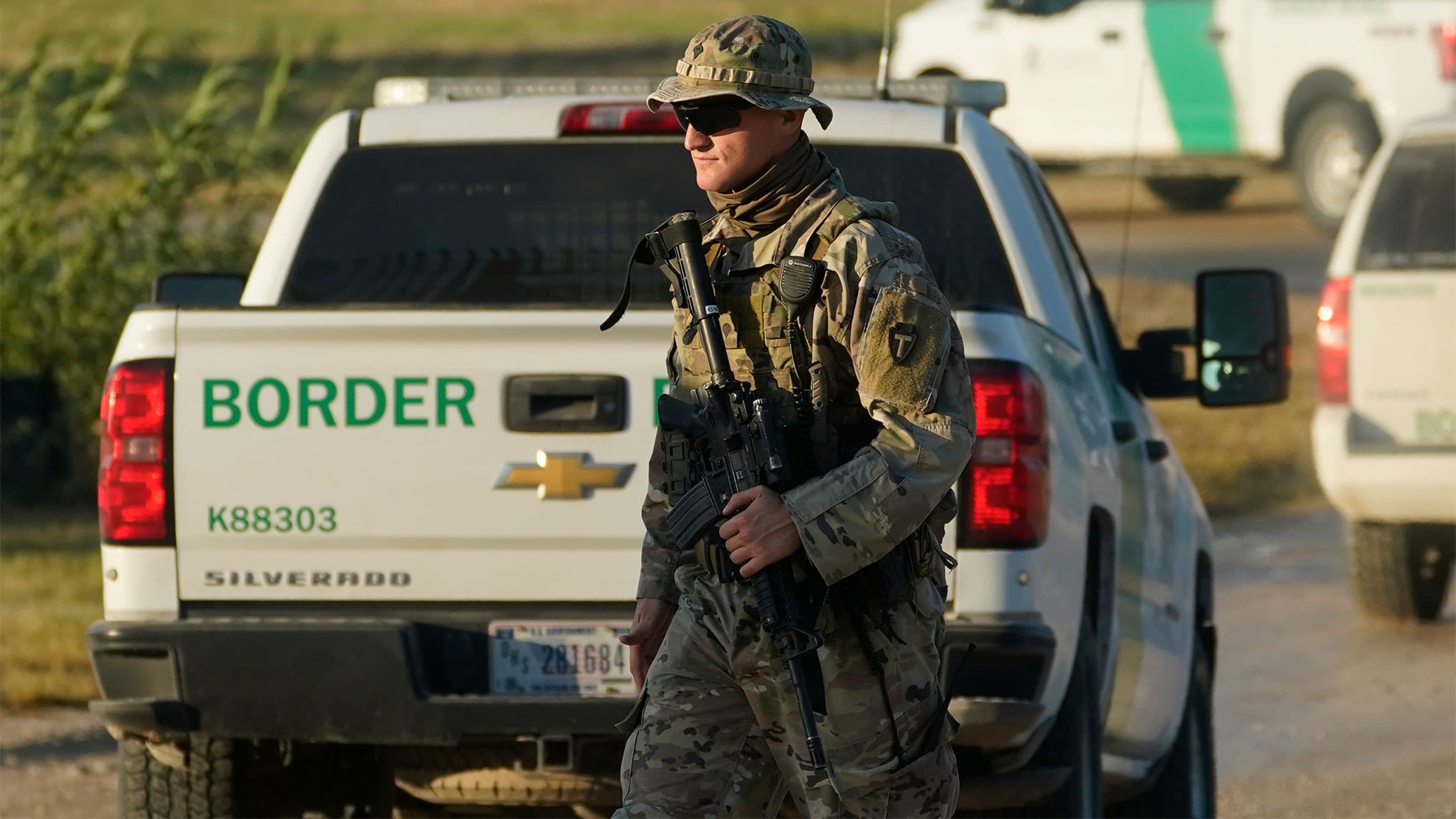 A National Guardsman walks along a border fence near the International Bridge where thousand of migrants, mostly from Haiti, have formed a makeshift camp in Del Rio, Texas