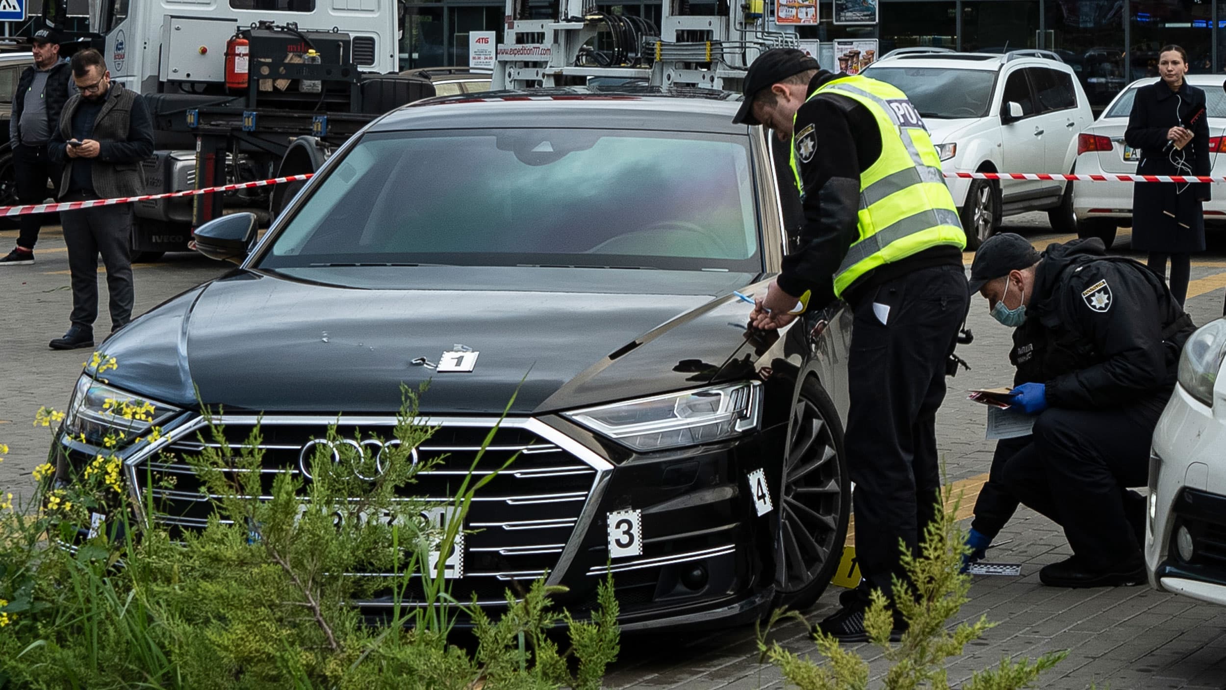 Police officers collect evidence near the car of Serhiy Shefir, first assistant to President Volodymyr Zelenskiy, that was shot at, near Kyiv, Ukraine