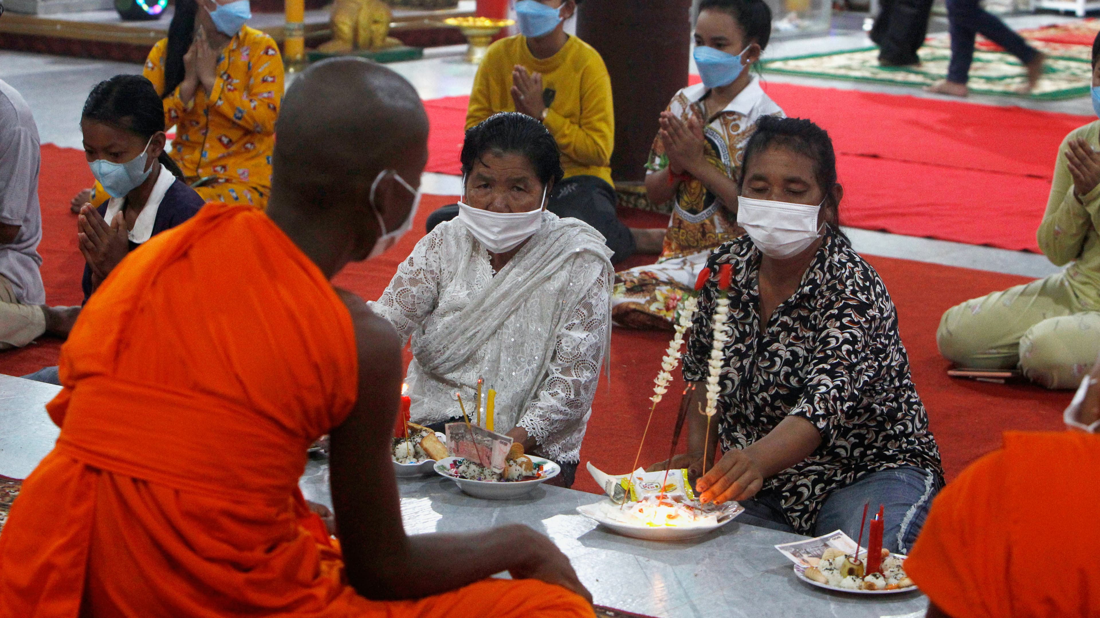 A Buddhist monk, foreground, chants as local residents offer prayer during a ceremony to celebrate Pchum Ben, or Ancestors' Day, at Kob Srov pagoda on the outskirts of Phnom Penh, Cambodia, Sept. 22, 2021. Cambodians on Wednesday began the celebration of