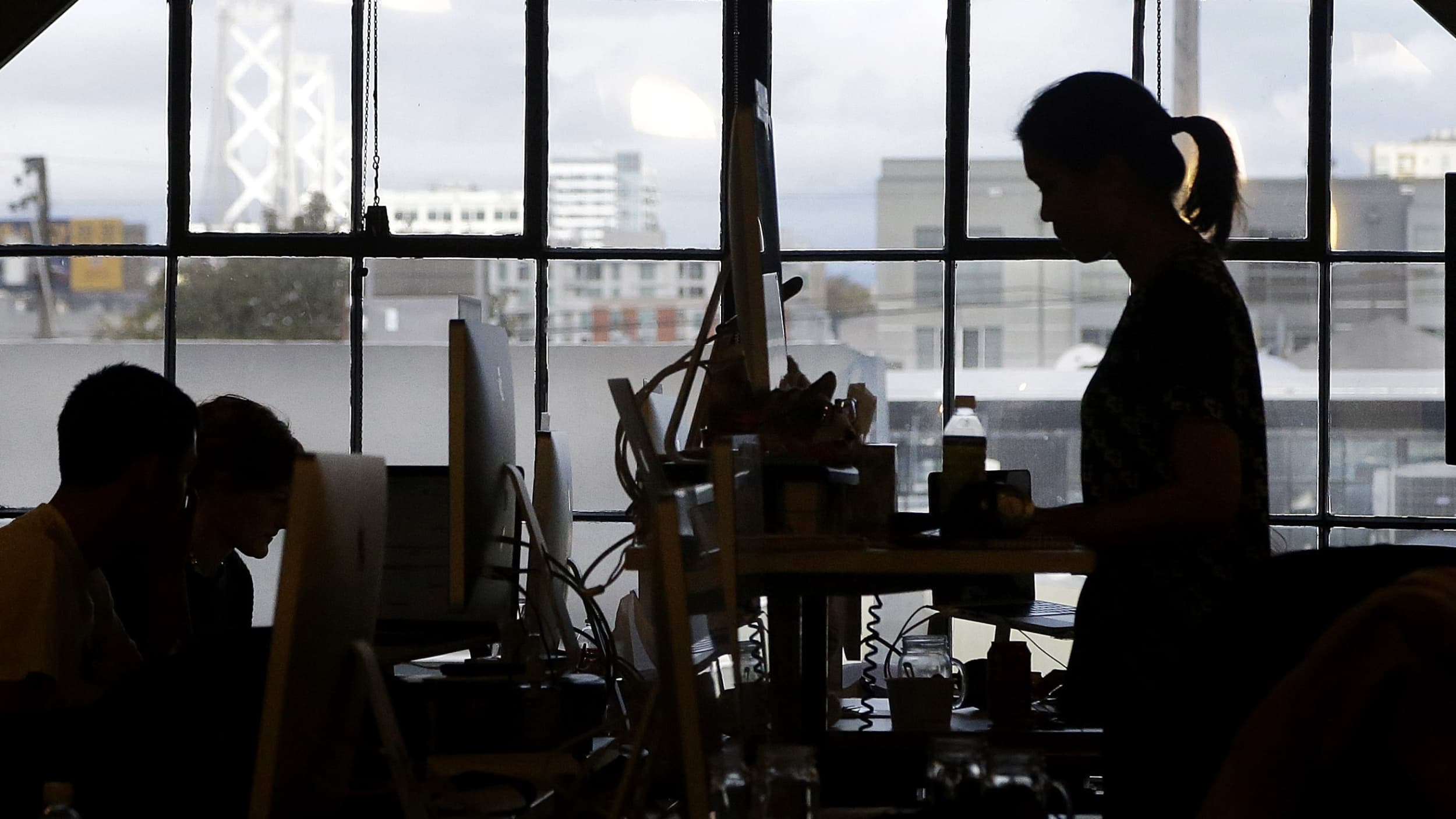 Office worker silhouetted in front of a window