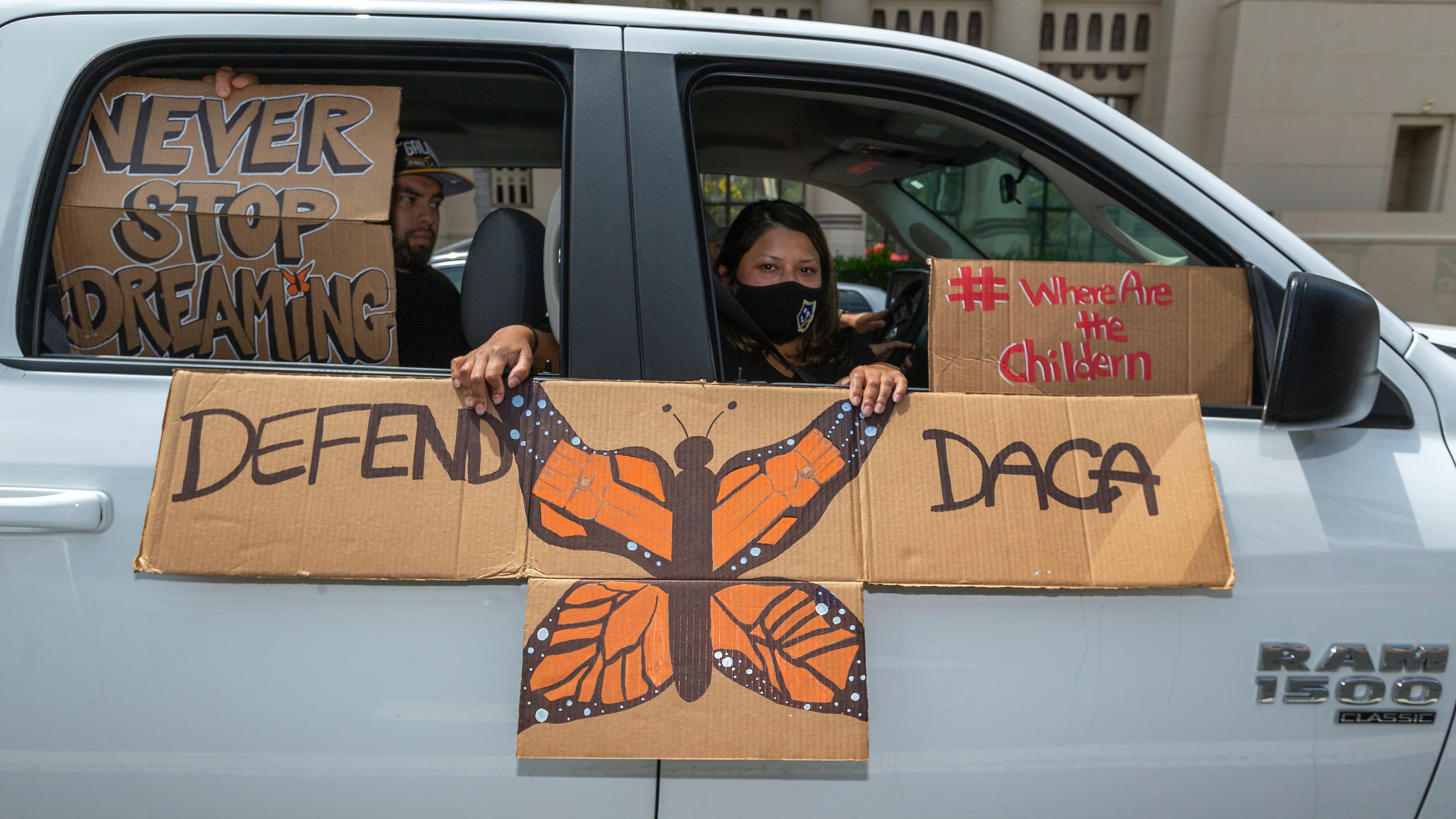 An immigrant family joins members of Coalition for Humane Immigrant Rights of Los Angeles, CHIRLA, on a vehicle caravan rally to support the Deferred Action for Childhood Arrivals Program (DACA), around MacArthur Park in Los Angeles, June 18, 2020.