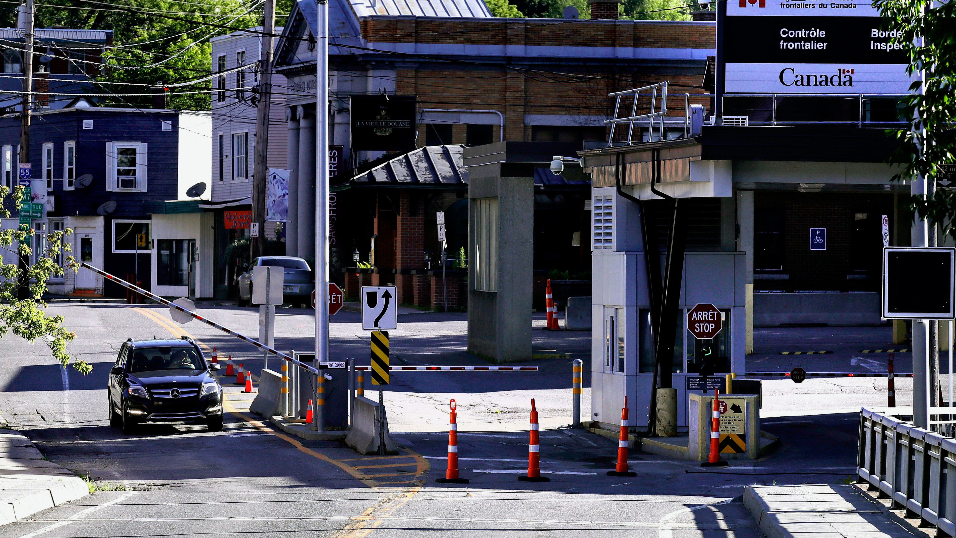 A vehicle in Canada waits for a gate to rise while crossing into Derby Line, Vt. from Stanstead, Quebec, July 11, 2018.