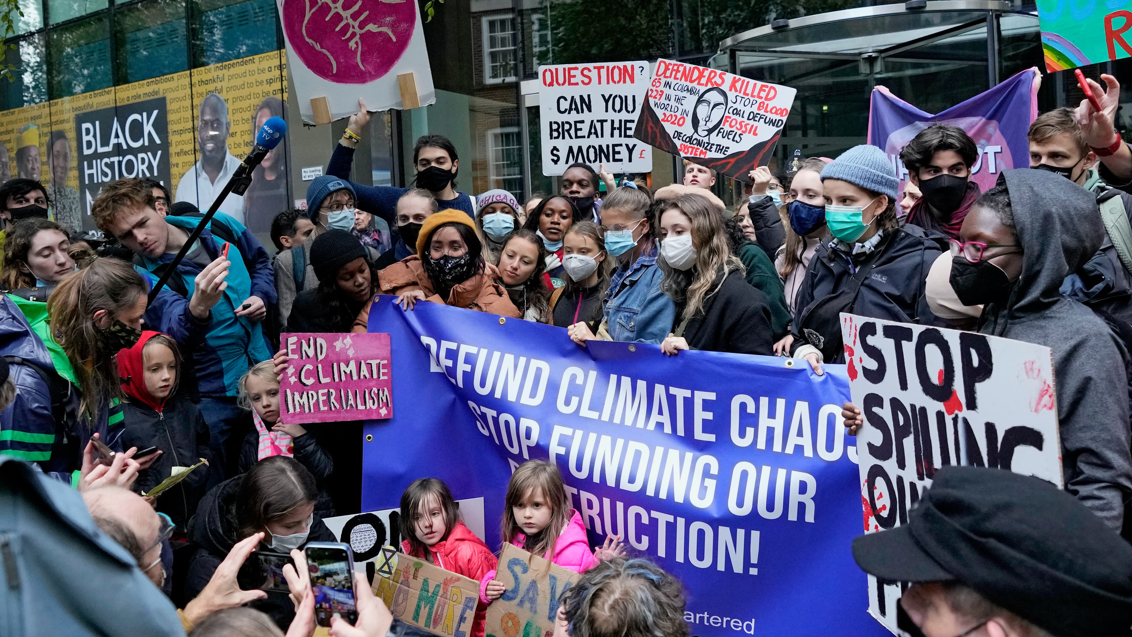 Climate activist Greta Thunberg, center, demonstrates with others in front of the Standard and Chartered Bank during a climate protest in London, Oct. 29, 2021. People were protesting in London ahead of the 26th UN Climate Change Conference (COP26), which