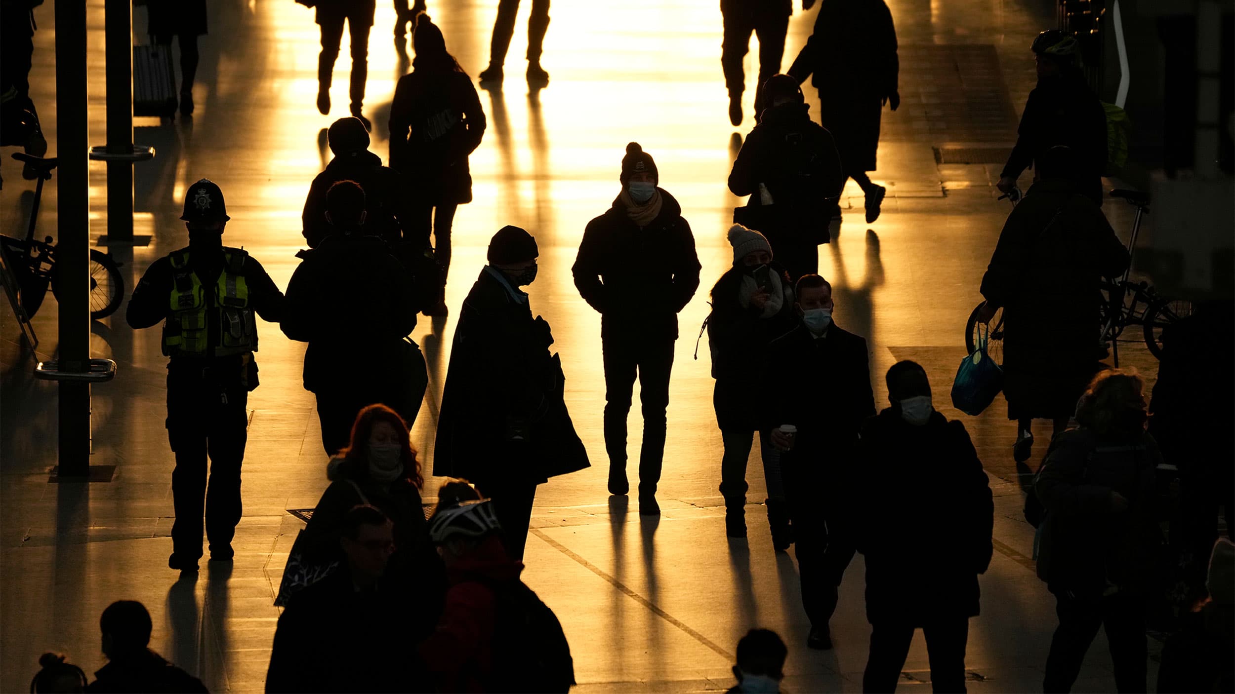 People pass through Waterloo train station, in London, during the morning rush hour