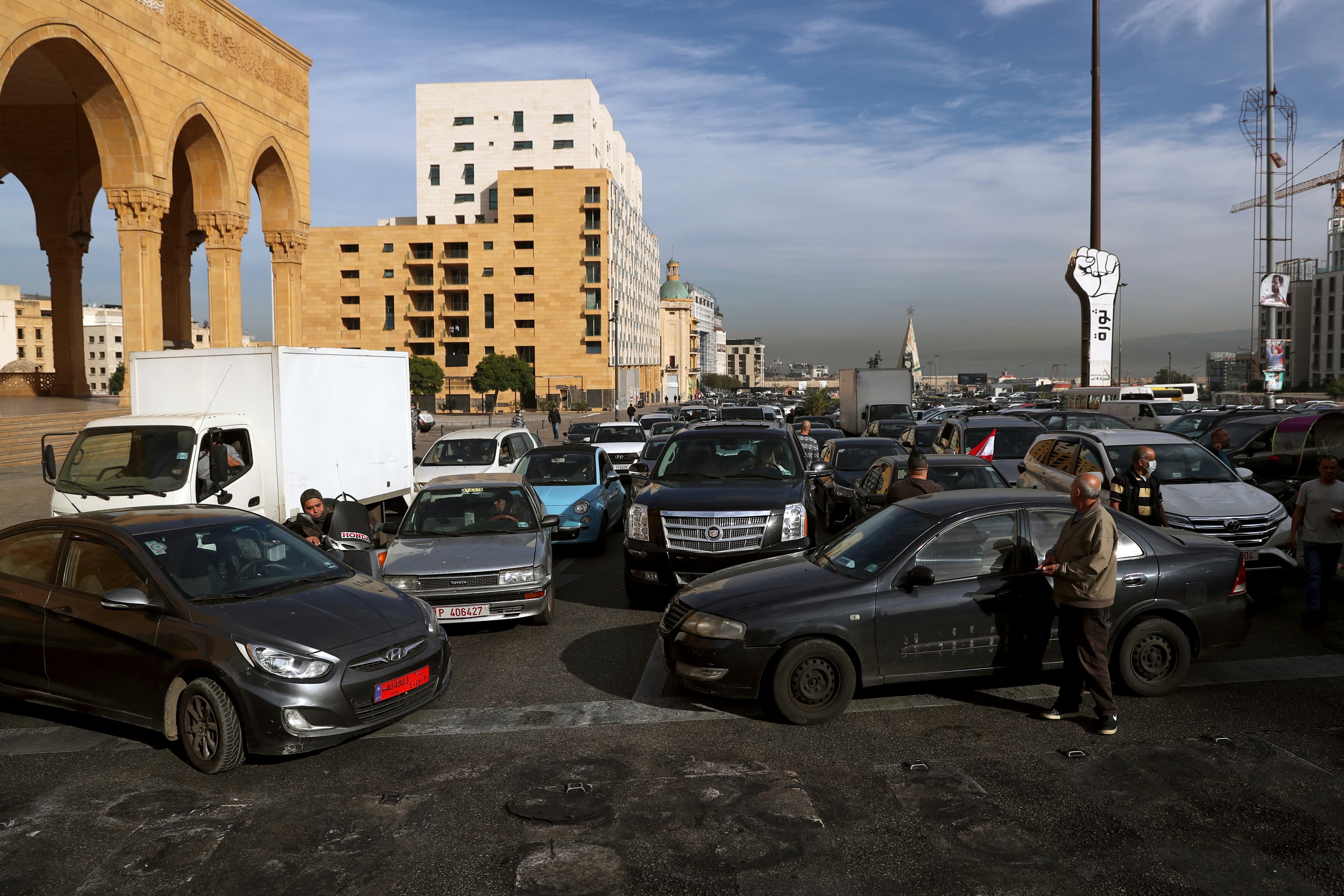 Taxi drivers block a road with their vehicles during a protest against the increasing prices of gasoline, consumer goods and the crash of the local currency, at Martyrs' Square, in downtown Beirut, Nov. 30, 2021.