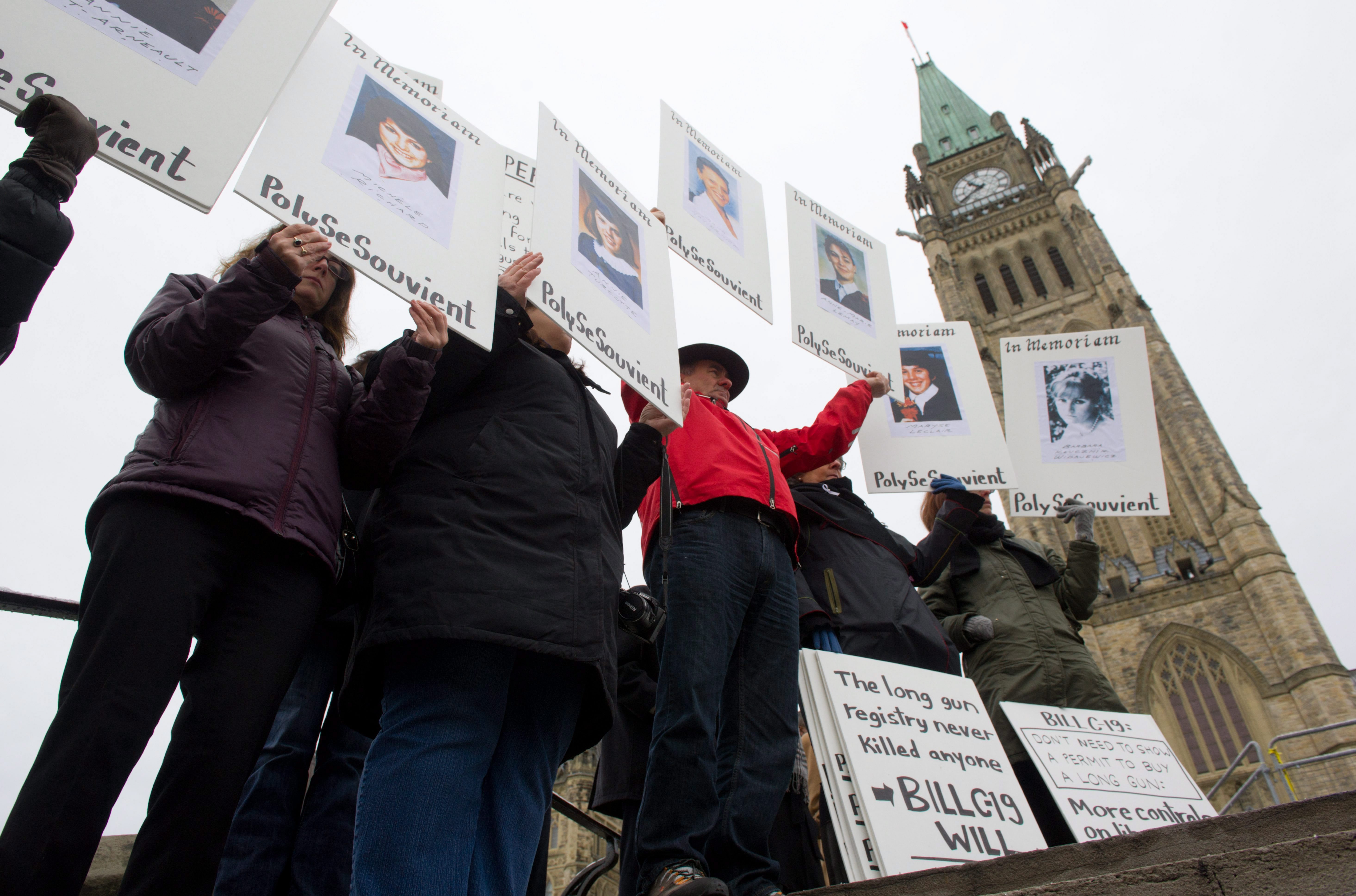 People holding up In Memoriam signs during a rally